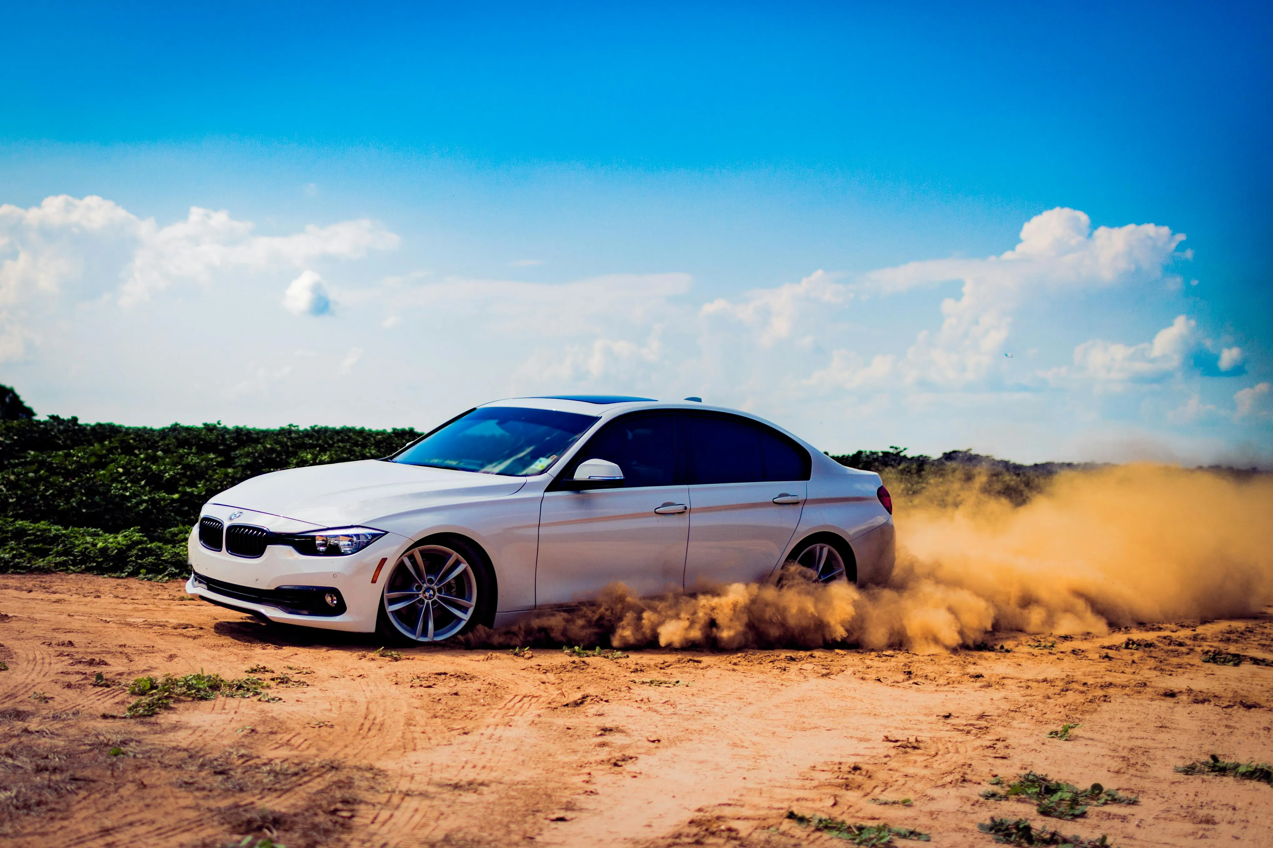 Bmw Sedan Driving Through Desert Terrain at High Speed