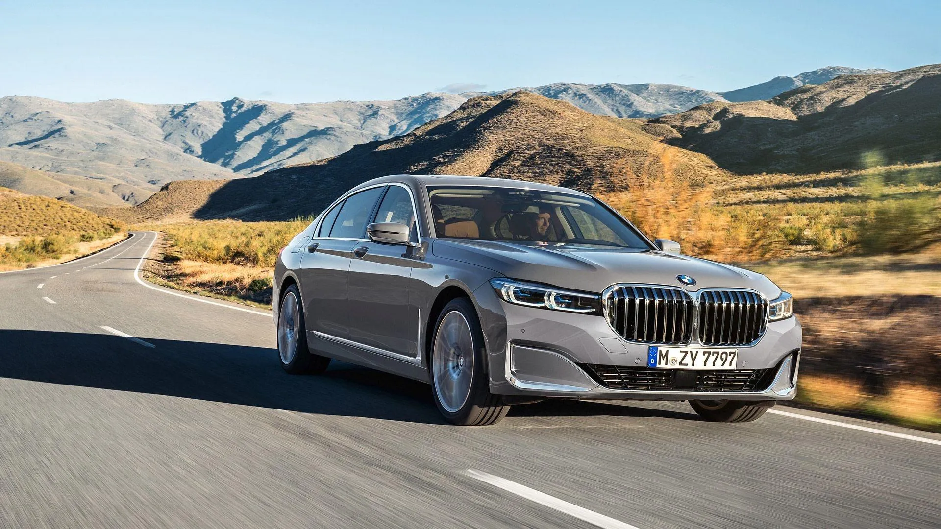 Bmw Sedan Driving Through Scenic Mountain Landscape