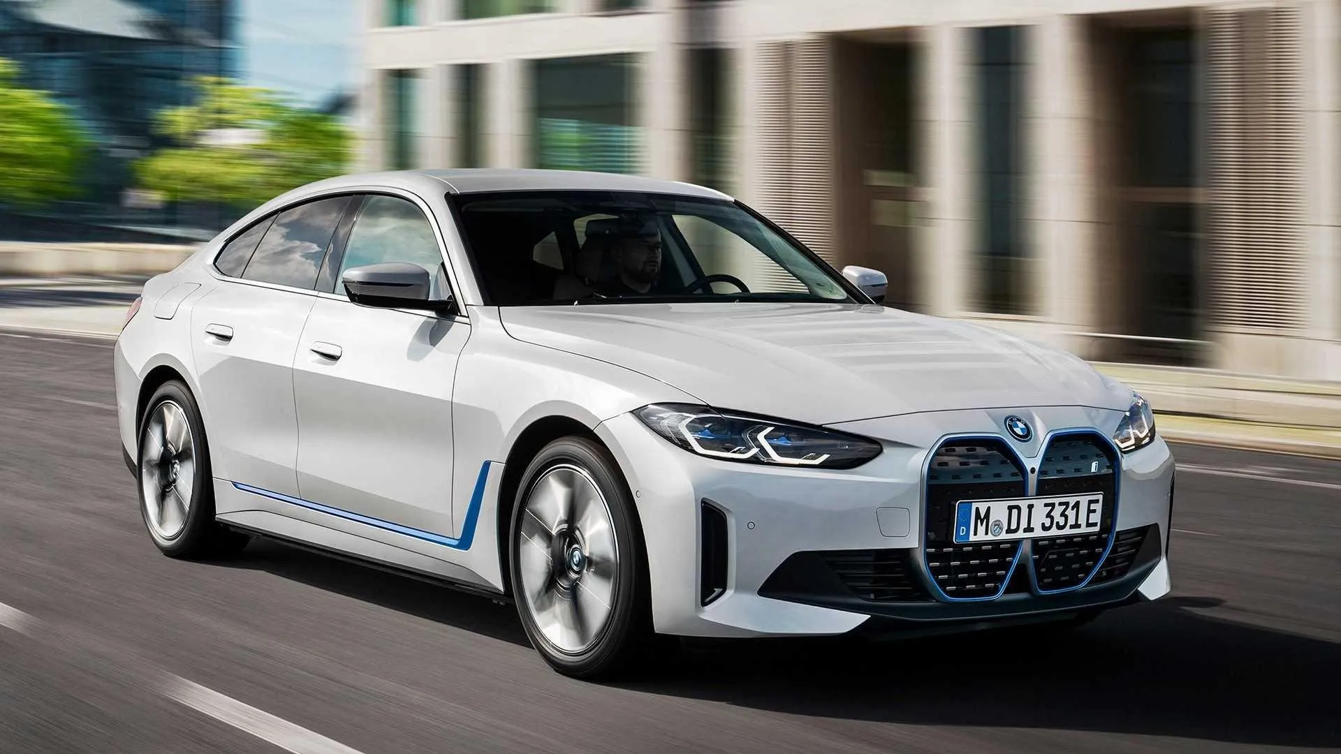 Bmw Sedan in Motion with Dynamic City Backdrop Wallpaper