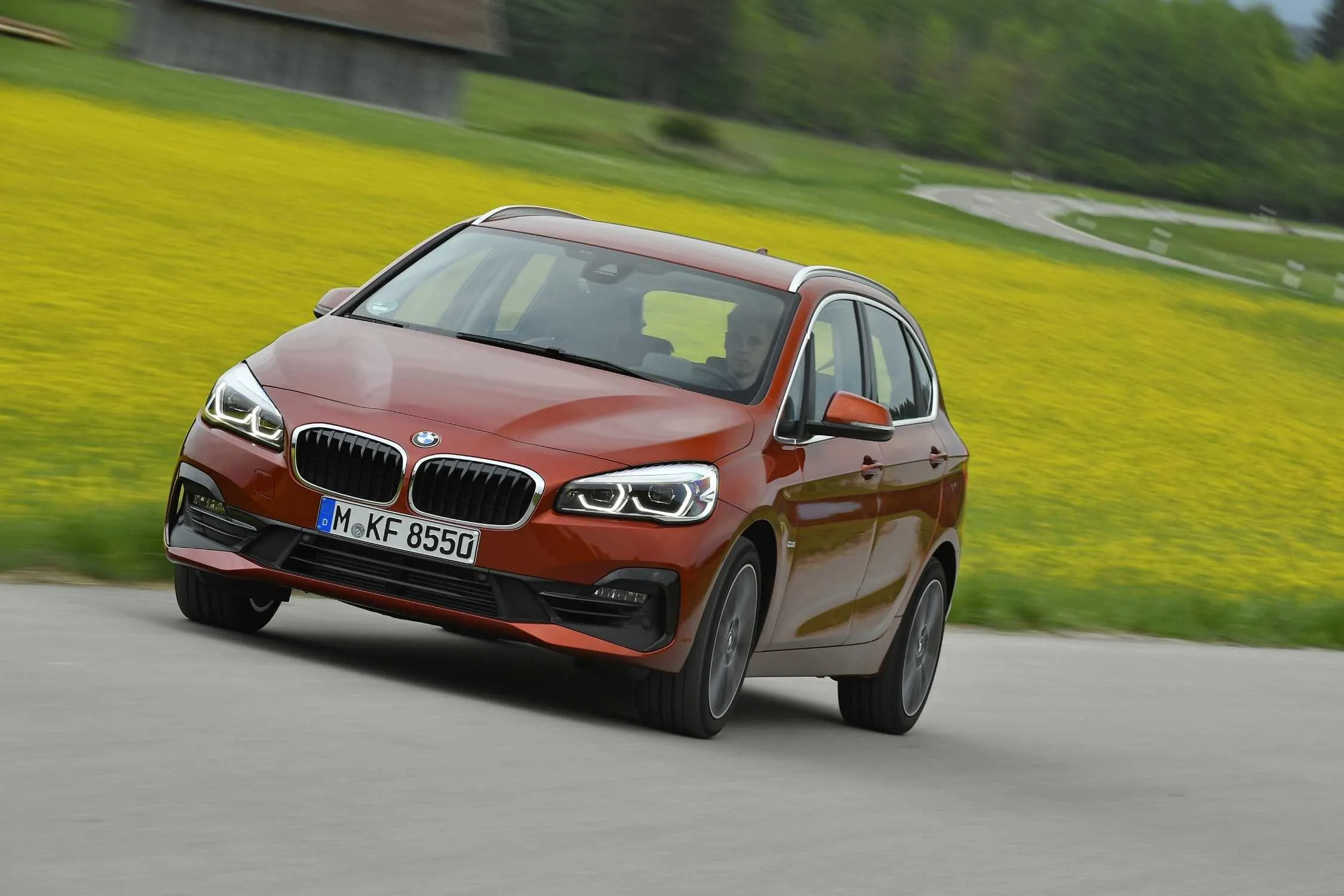 Bmw Sedan on Open Road with Lush Green Landscape