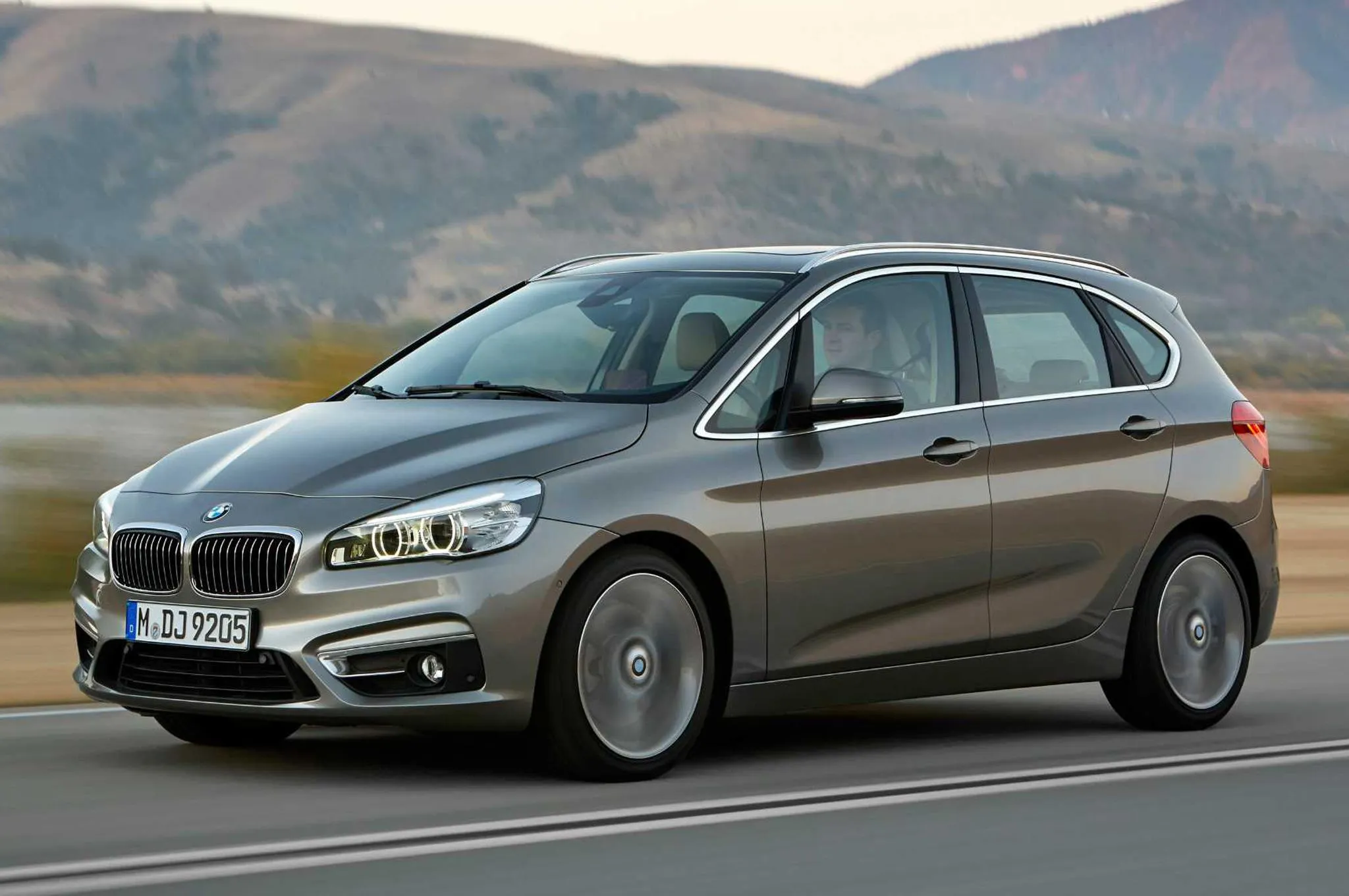 Bmw Sedan on Open Road with Mountain Landscape Backdrop