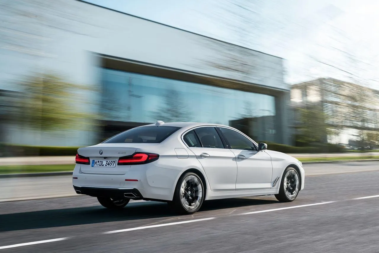 Bmw Sedan Speeding on City Road Beside Glass Building