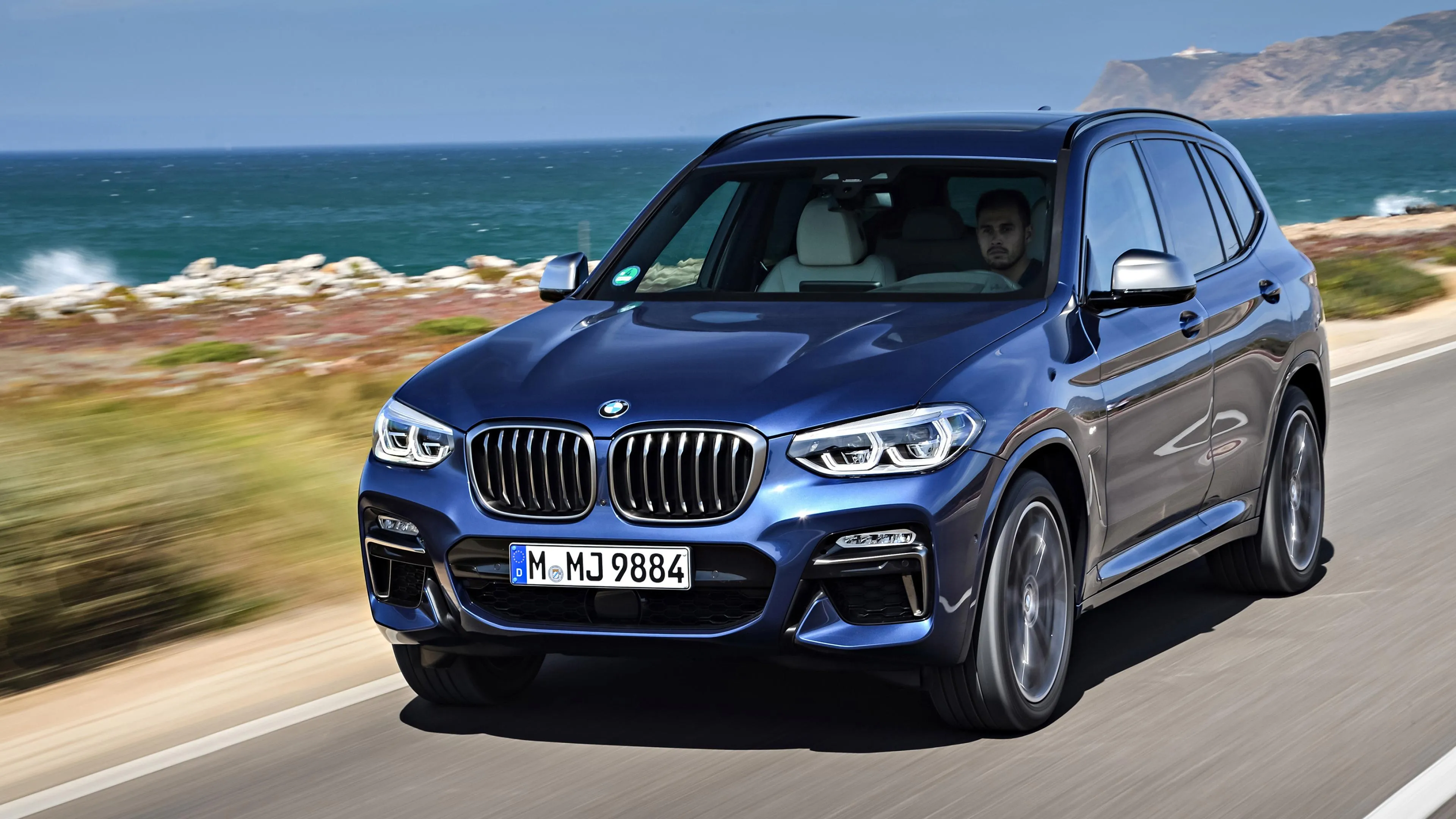 Bmw Suv Driving Along a Coastal Highway Hd Wallpaper