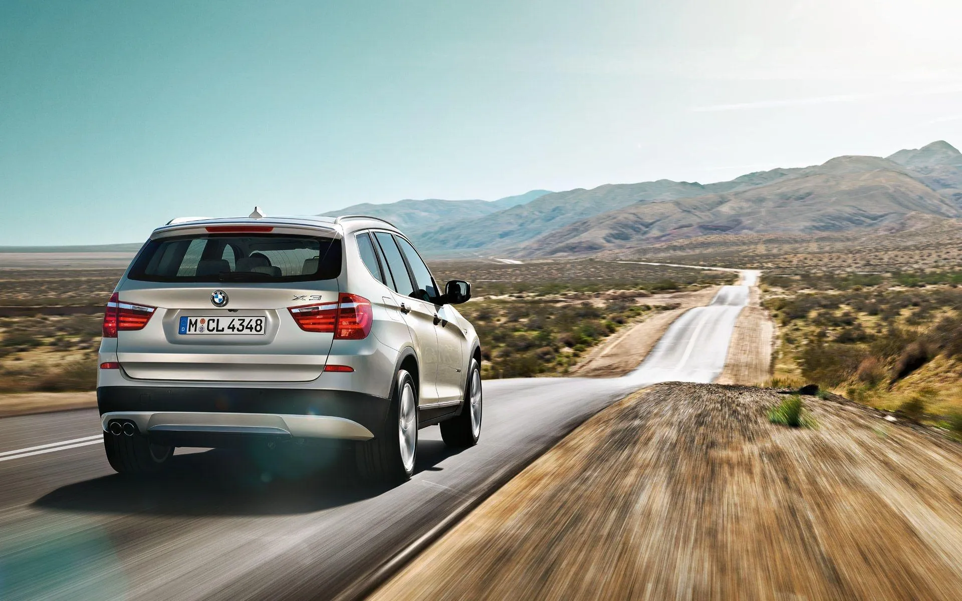 Bmw Suv Driving Down Open Highway with Mountains in View