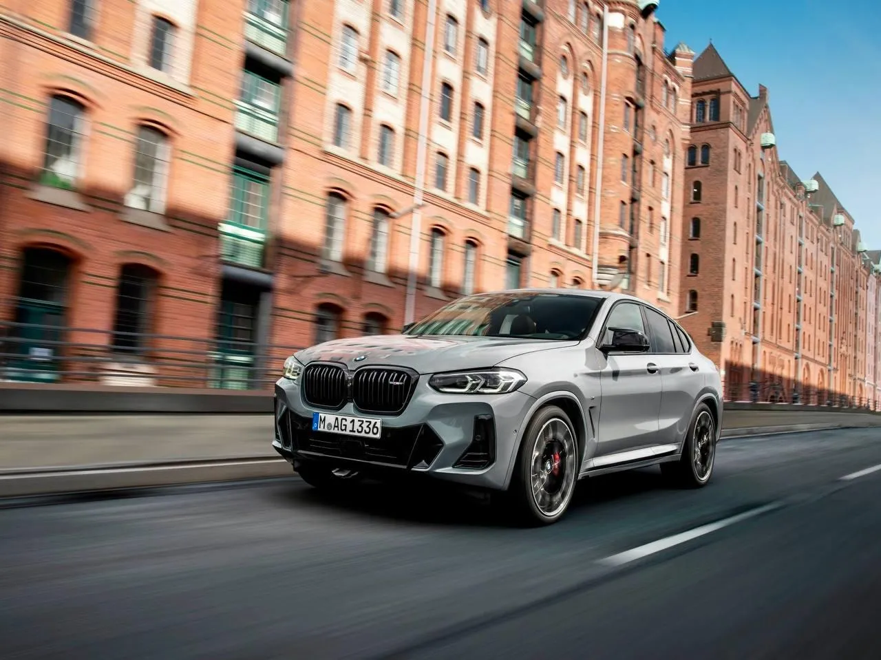 Bmw Suv Driving in the City with Modern Buildings Wallpaper