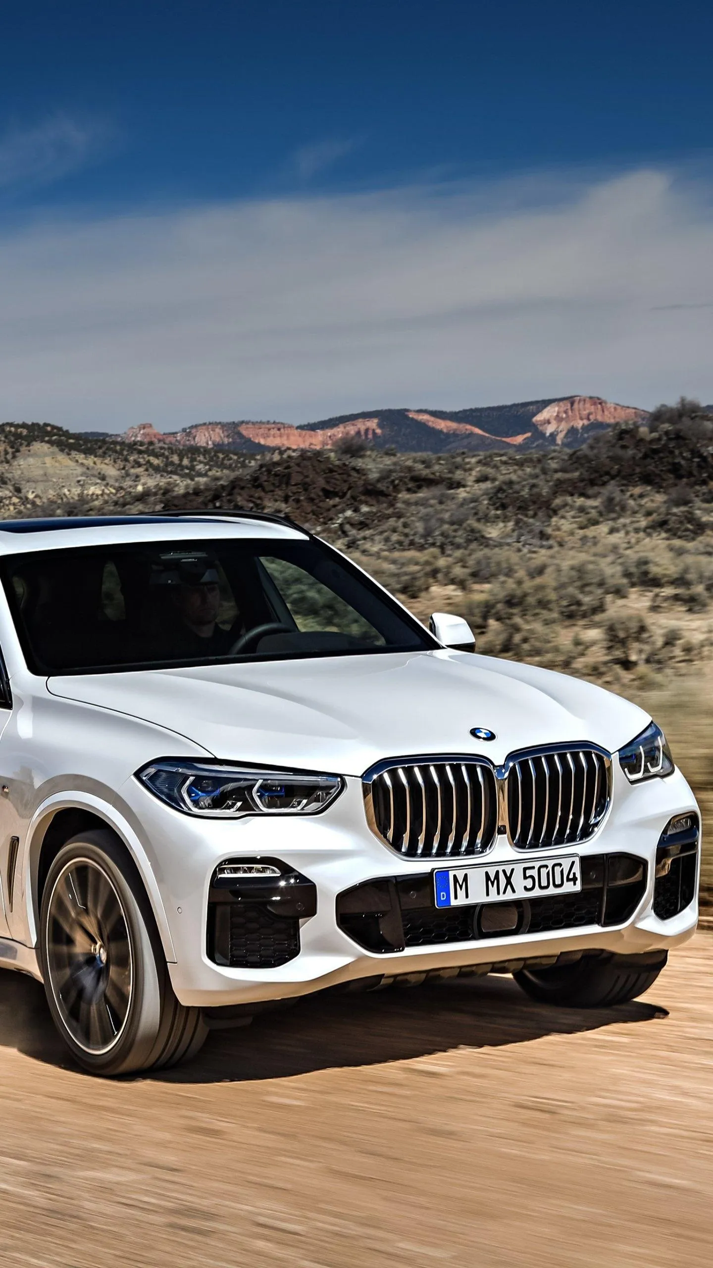 Bmw Suv Driving Off Road with Mountains in the Back