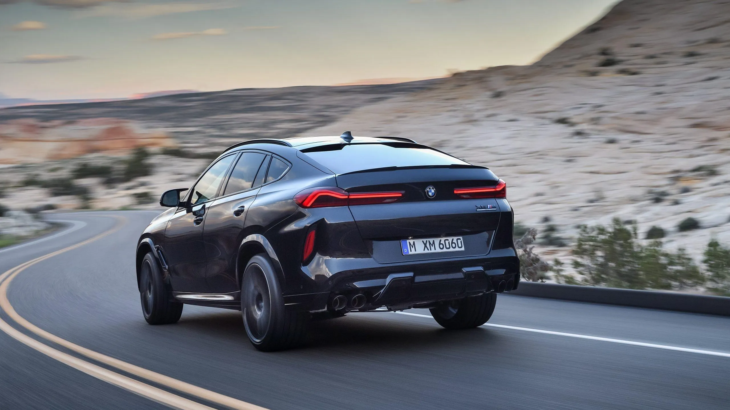 Bmw Suv Driving on Desert Highway with Rocky Hills Ahead