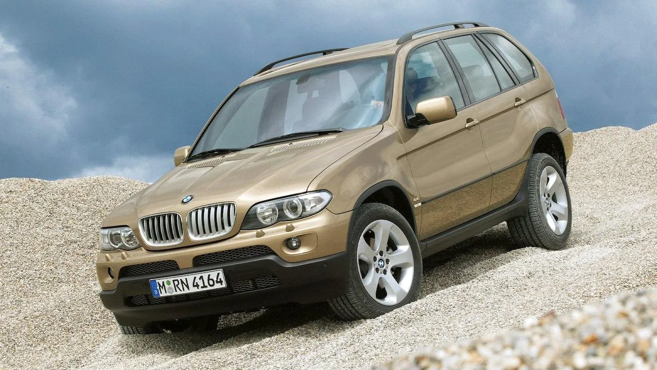 Bmw Suv Driving on Rocky Terrain with Dusty Background