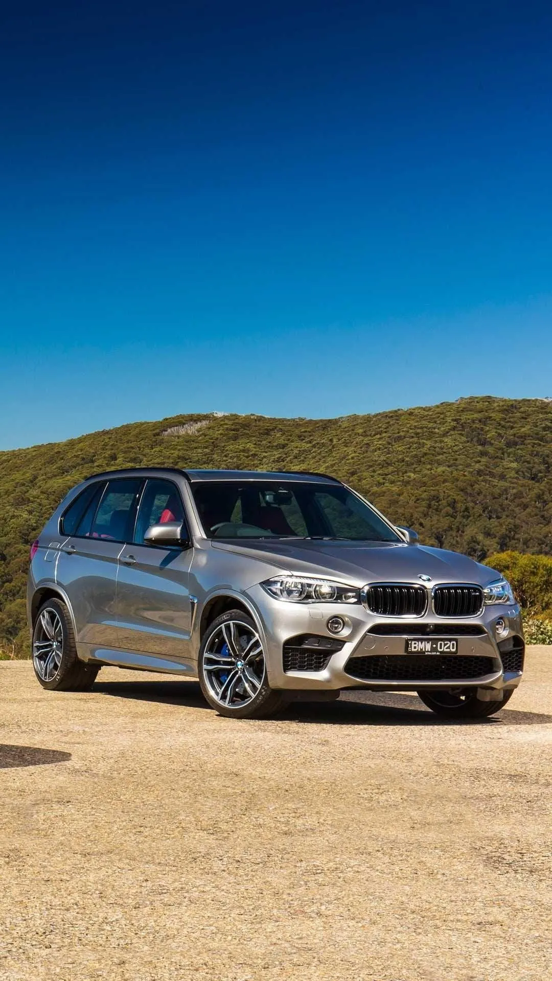 Bmw Suv Driving on Sandy Terrain Under Clear Blue Sky