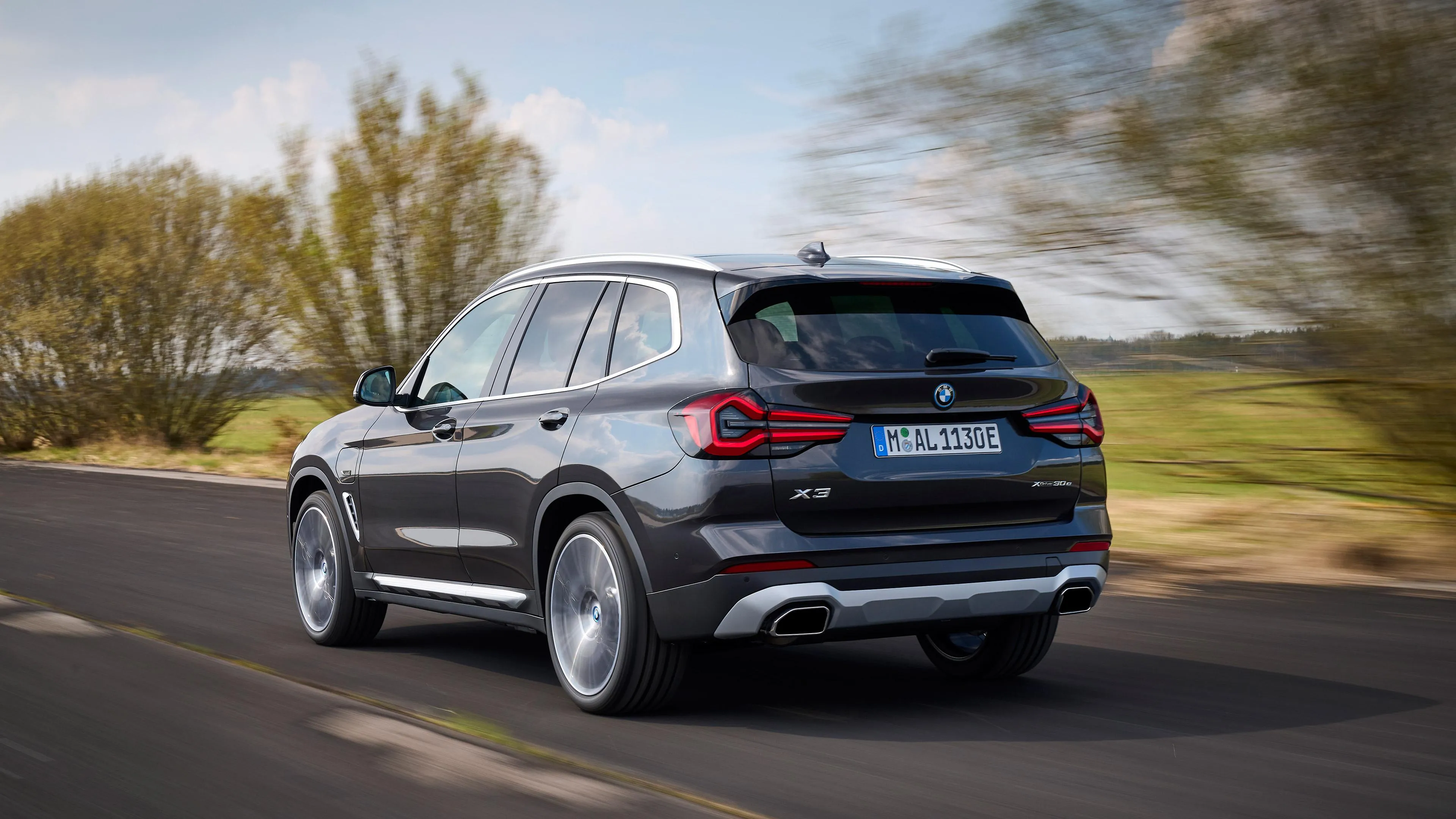 Bmw Suv Driving on Suburban Road with Trees on Both Sides