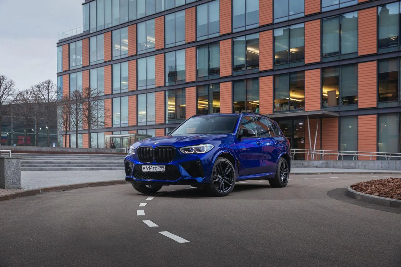 Bmw Suv Driving Through a Stylish Urban Area Wallpaper