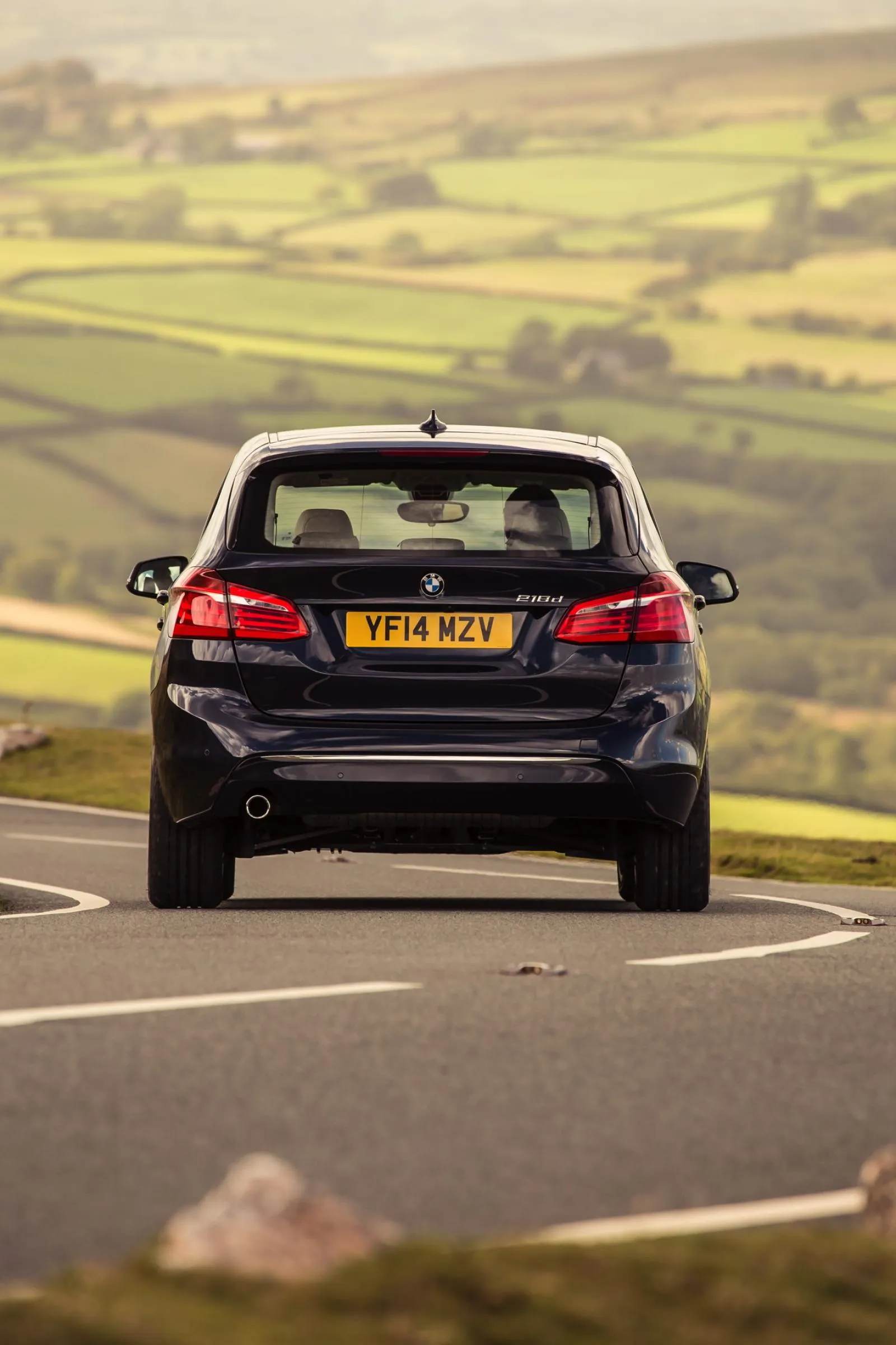 Bmw Suv Driving Through Countryside with Lush Green Hills