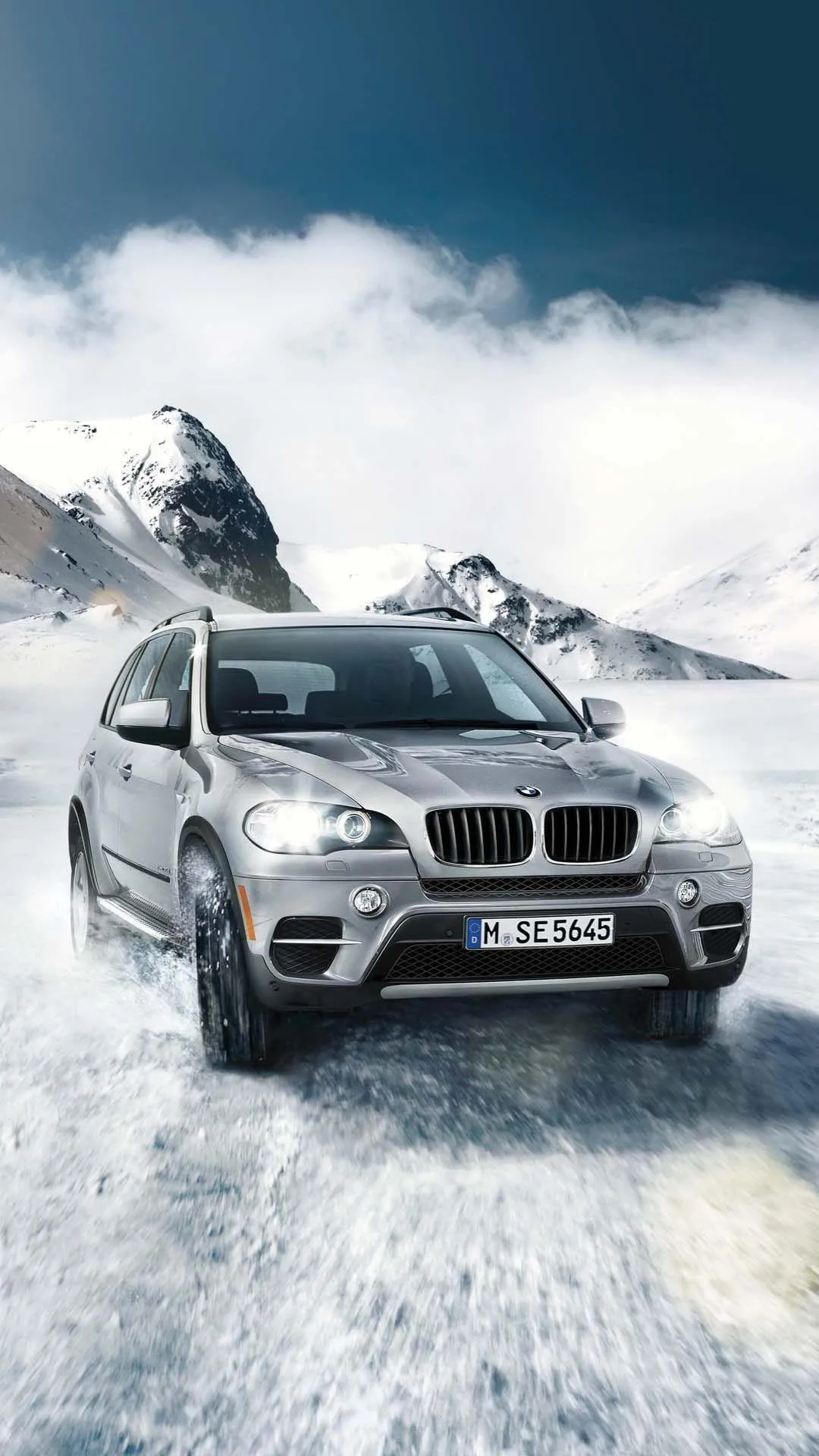 Bmw Suv Driving Through Snowy Terrain with Mountains