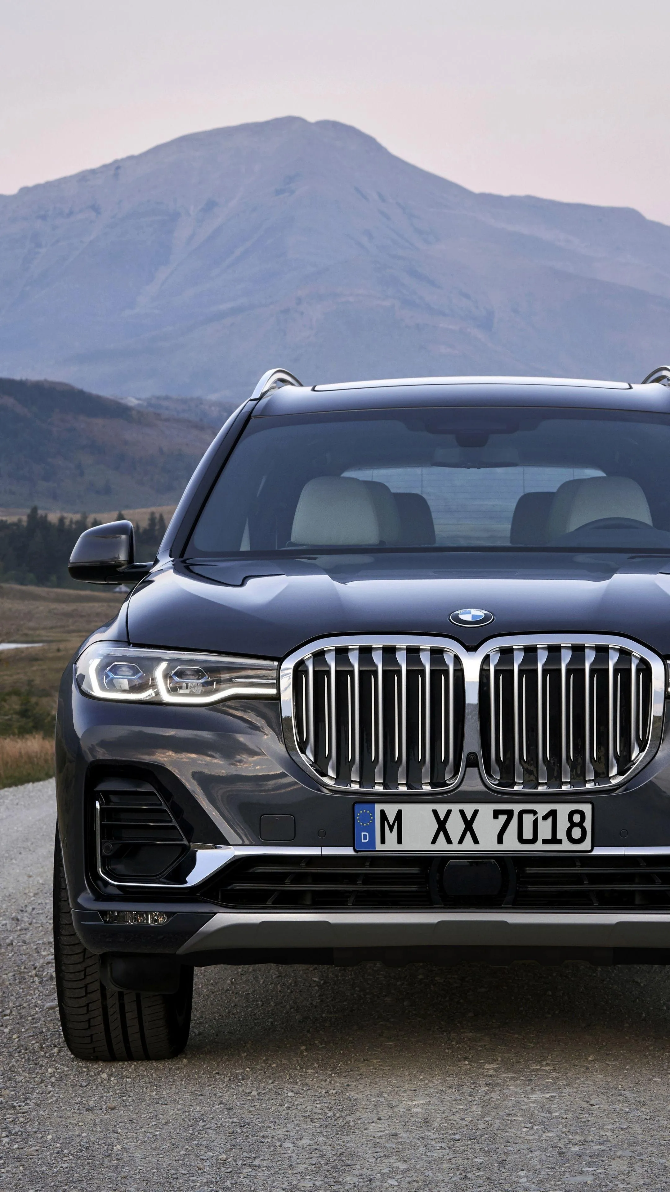 Bmw Suv Front View with Mountains and Cloudy Sky