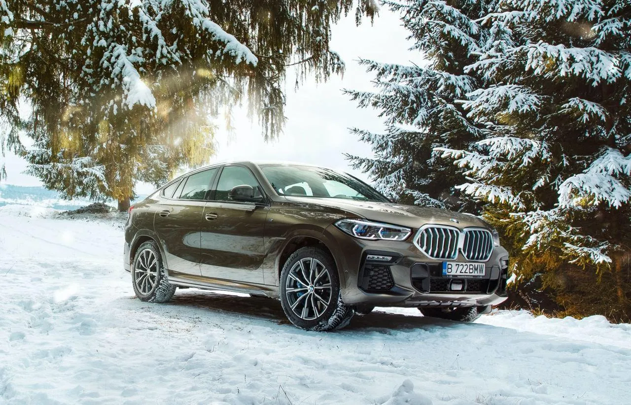 Bmw Suv in a Snowy Forest Landscape with Sunlight Glare