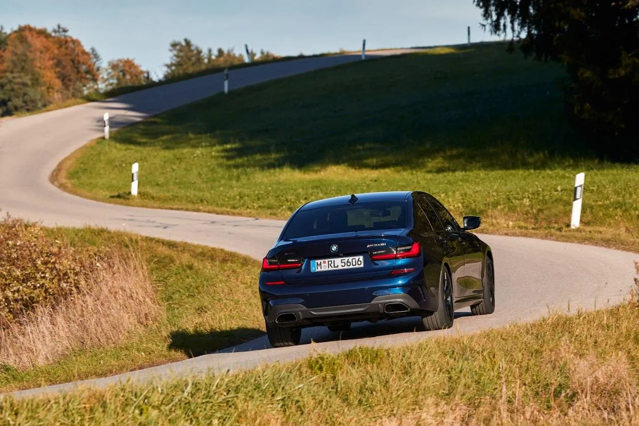 Bmw Suv Model Driving on a Picturesque Rural Road Wallpaper