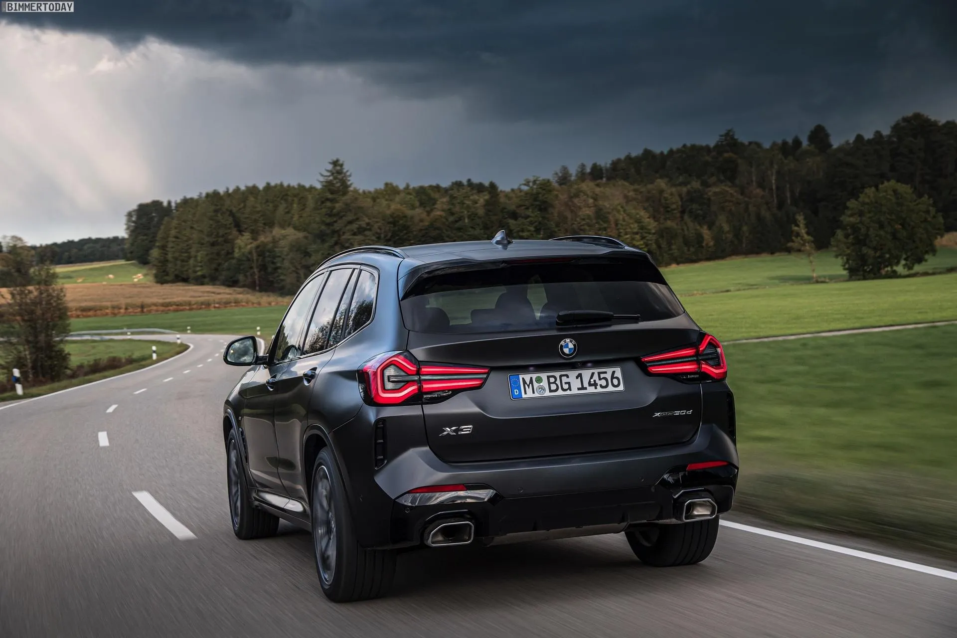 Bmw Suv on Country Road with Forest and Hills in Background