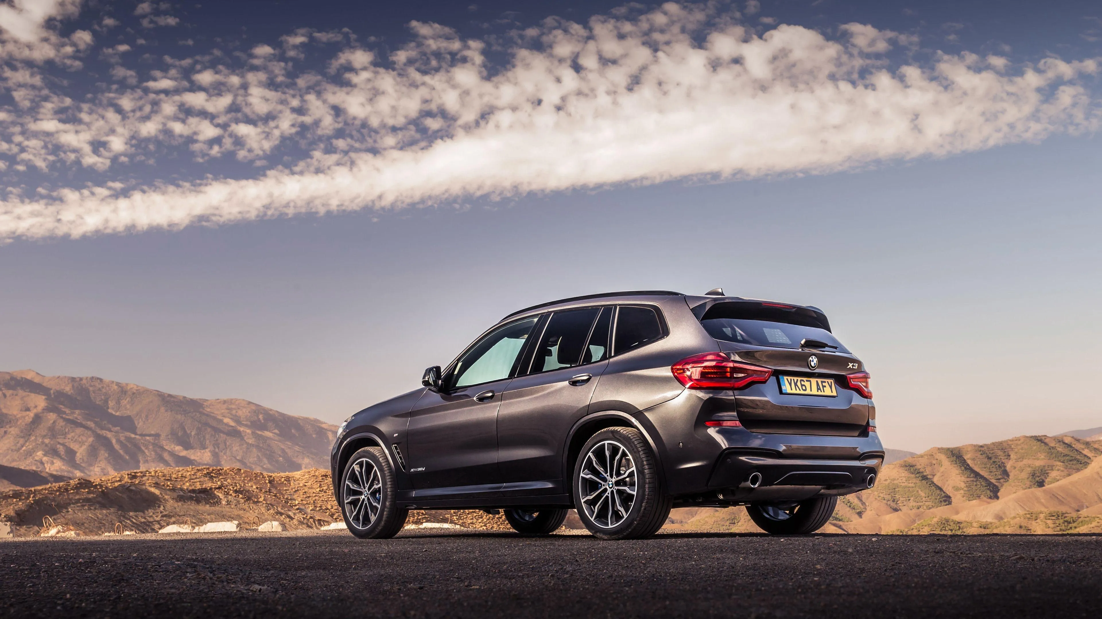 Bmw Suv Parked in Desert Landscape Under Blue Sky Image