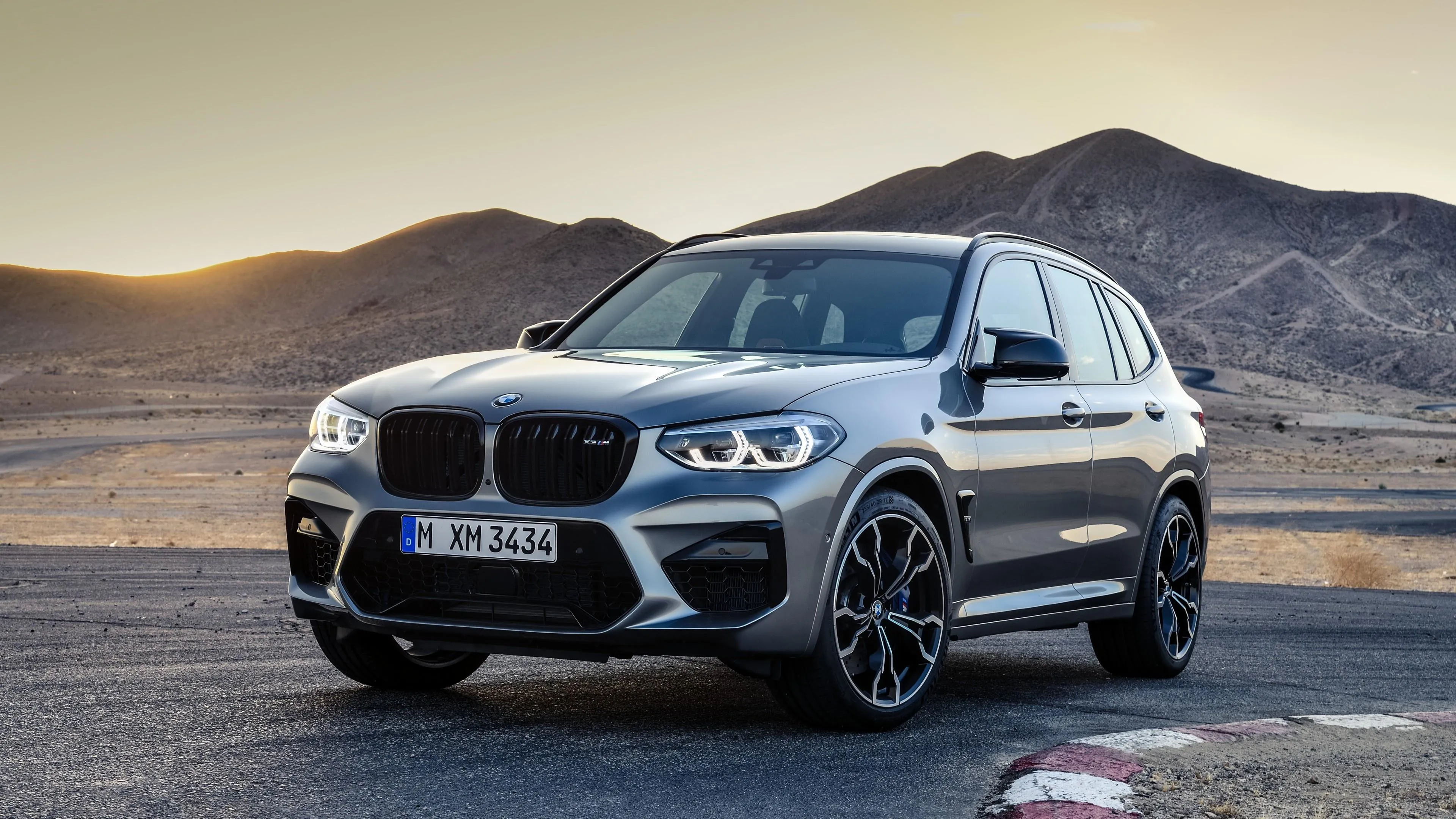 Bmw Suv Parked in Desert Landscape with Mountains Behind