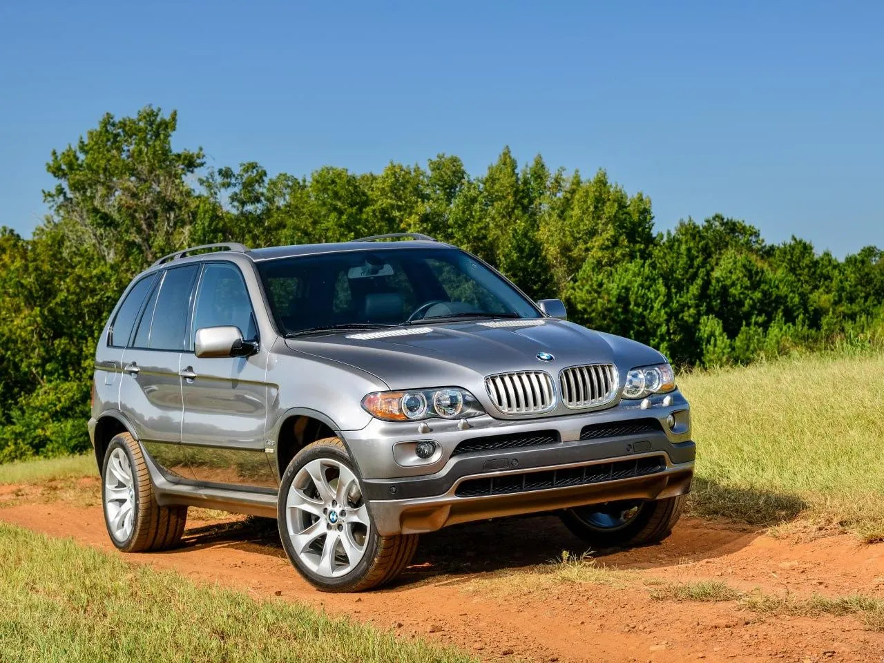 Bmw Suv Parked on a Dirt Road with a Scenic Backdrop