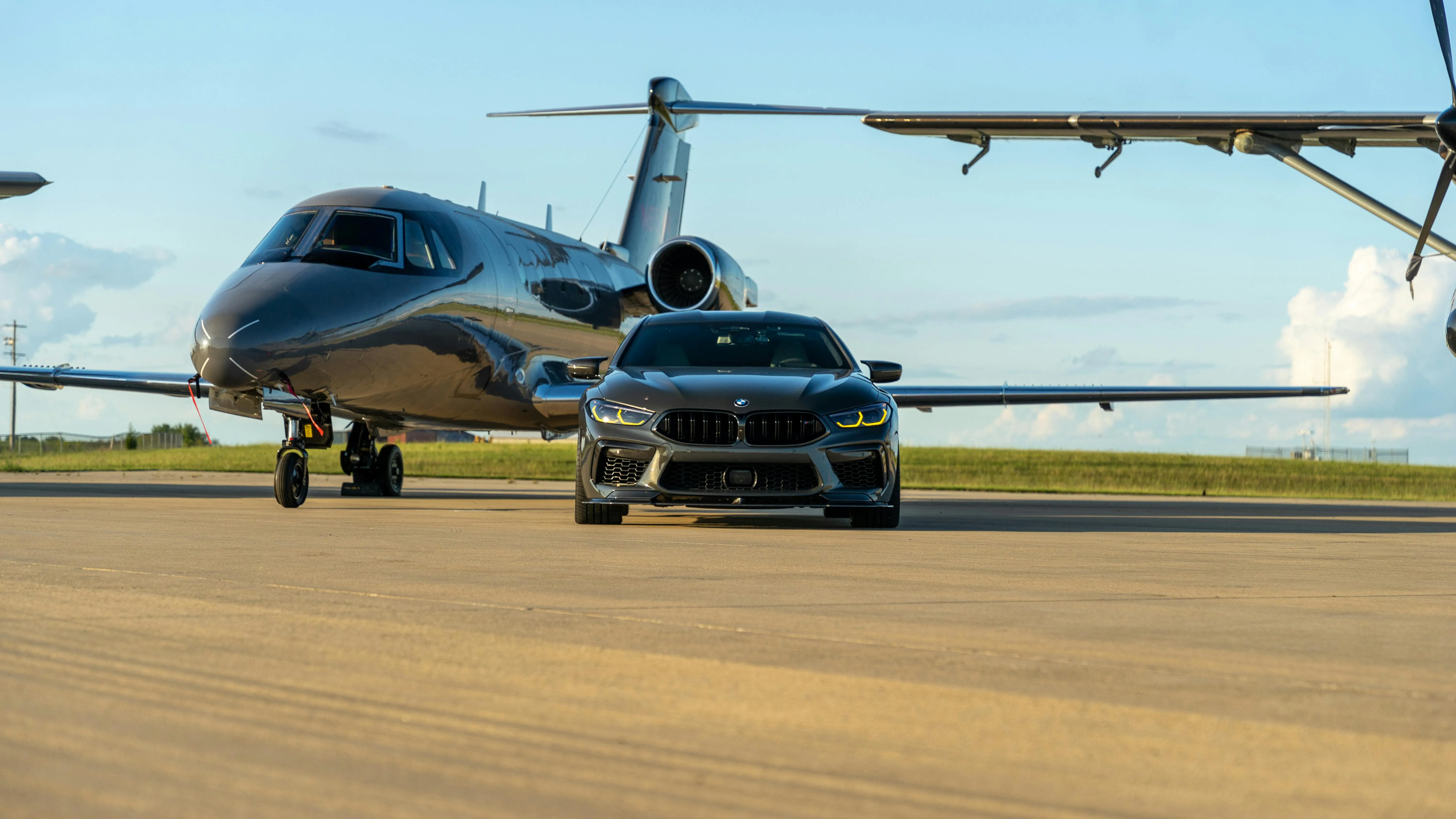 Bmw Suv Parked on Airport Runway Beside Private Jet