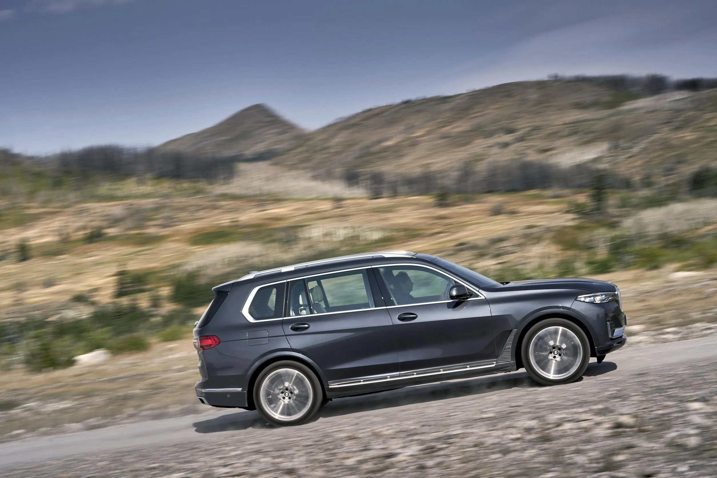 Bmw Suv Parked on Desert Roadside with Mountains Behind