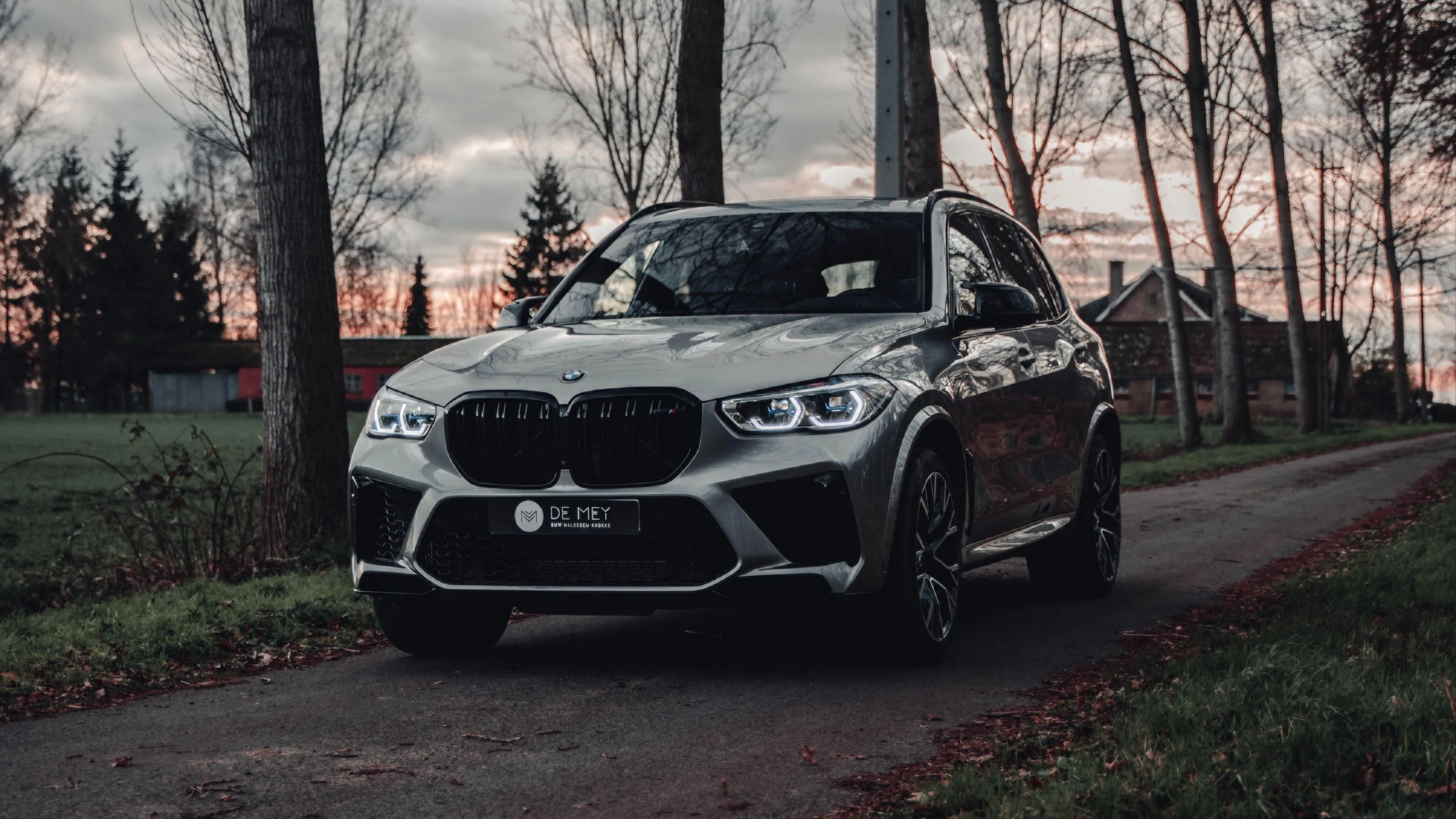 Bmw Suv Parked on Forest Road with Cloudy Sky Overhead
