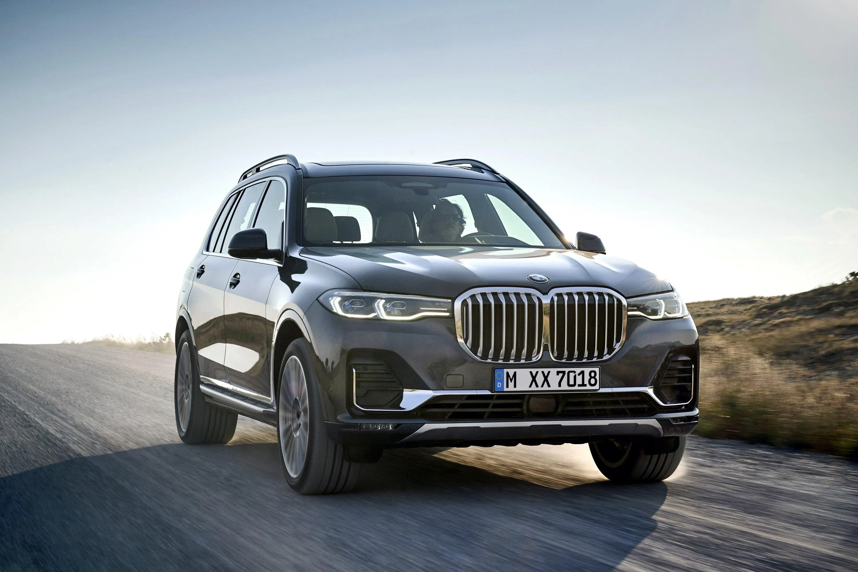 Bmw Suv Posing on Road with Light Background Wallpaper