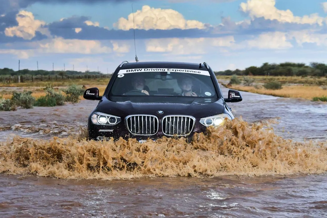 Bmw Suv Splashing Through Muddy Water on Offroad Trail