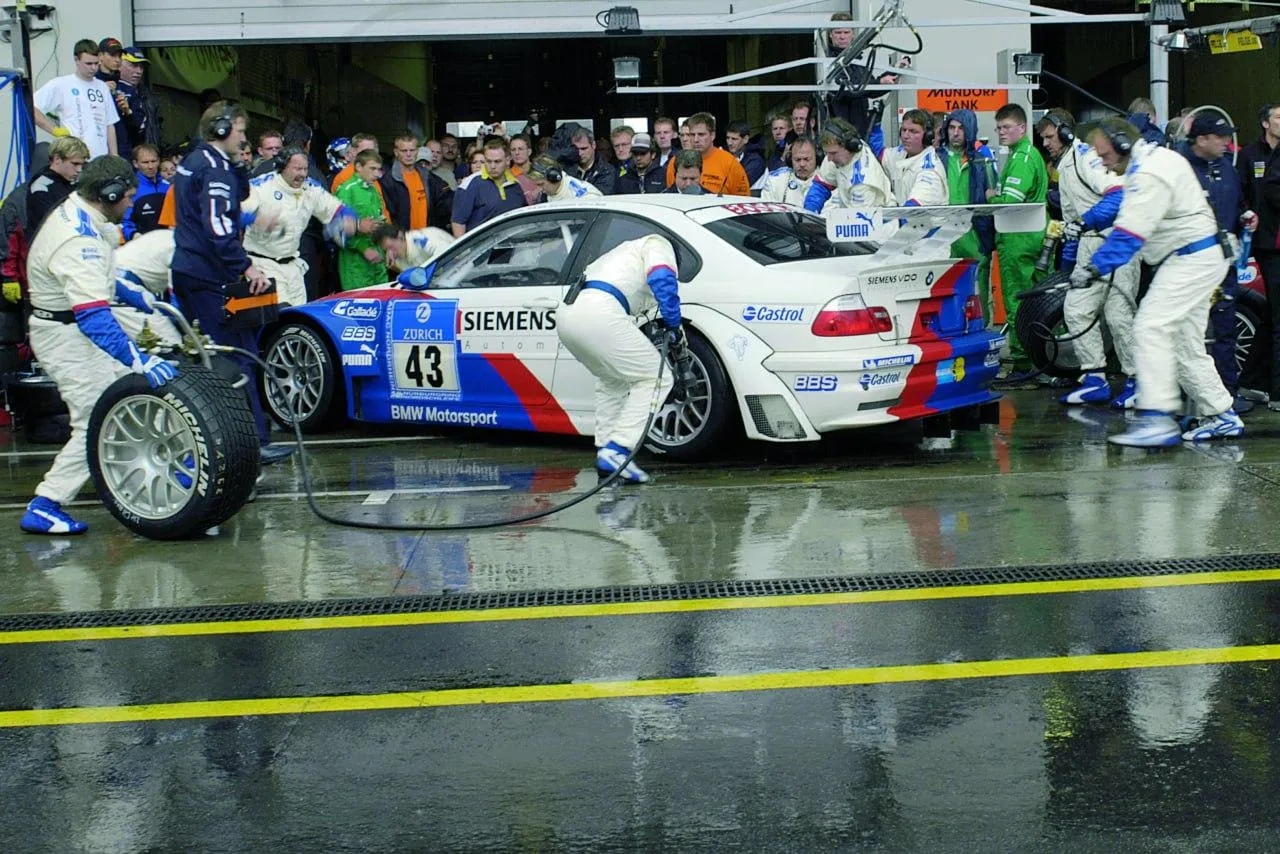 Bmw Team in Pit Stop During a Rainy Race with Crew Working