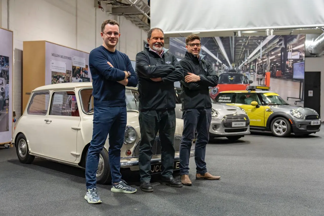 Bmw Team Posing with Vintage Car at an Exhibition Wallpaper