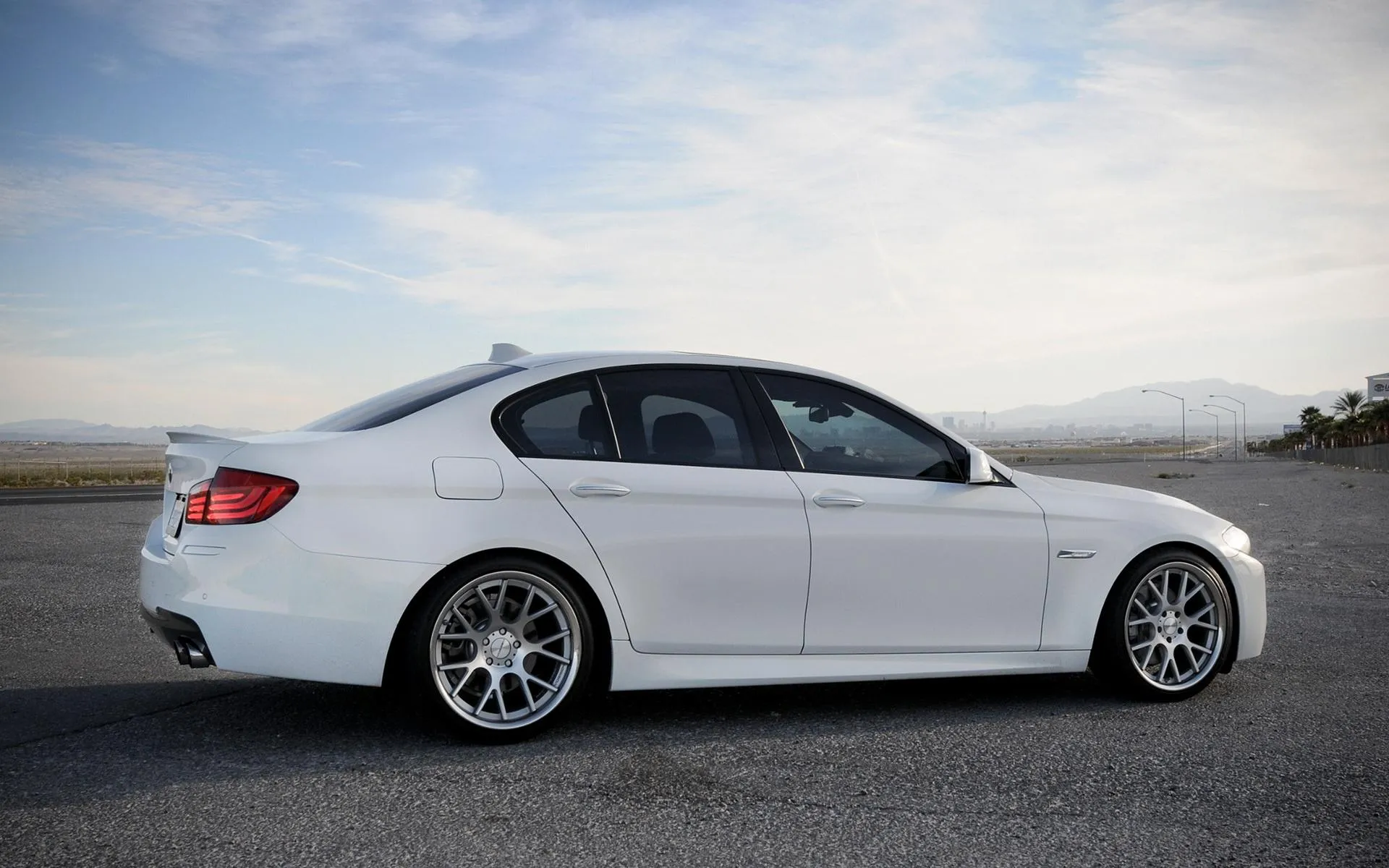 Bmw White Sedan on the Road in Scenic Landscape Wallpaper