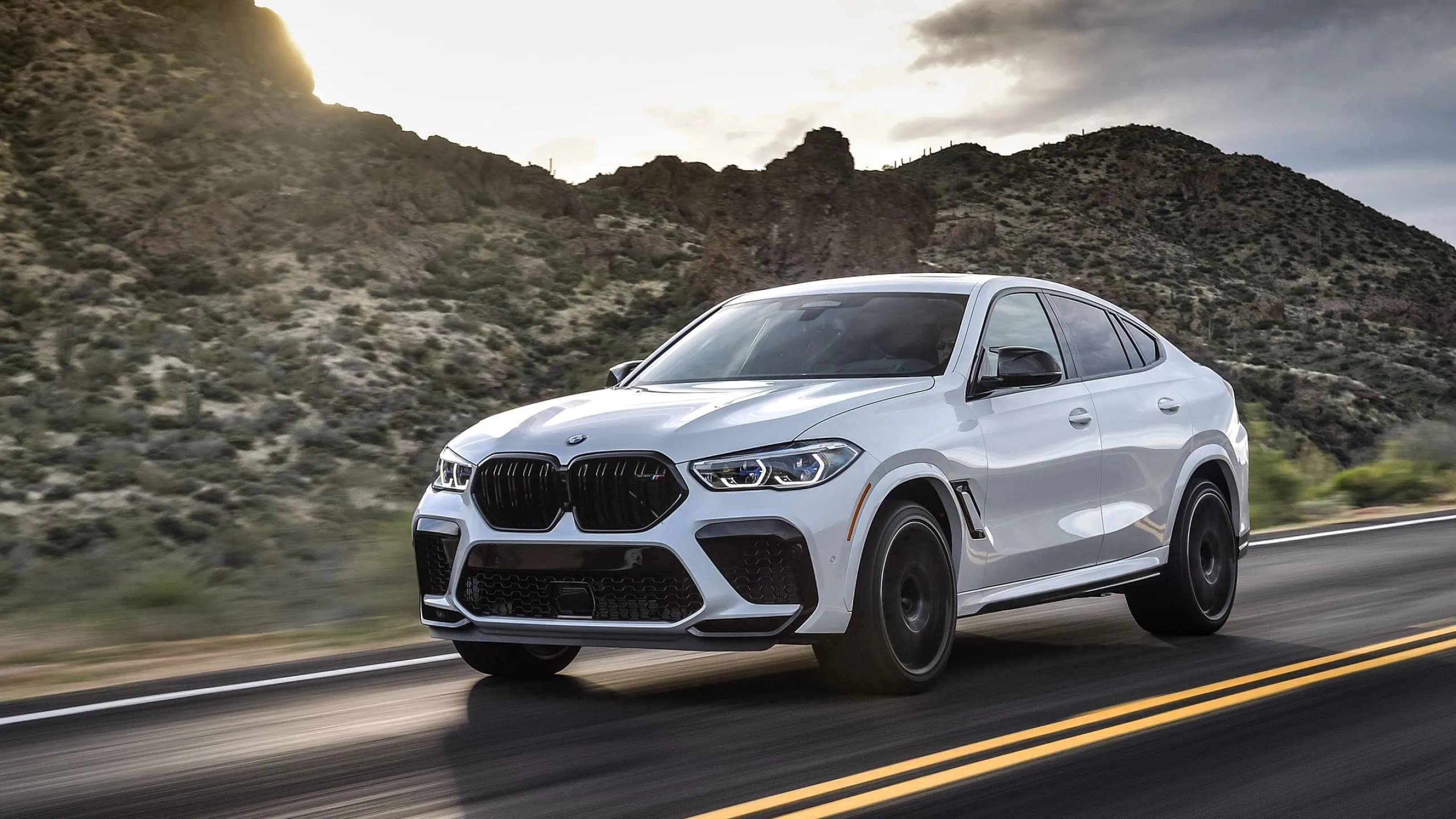 Bmw White Suv Driving on Highway with Rocky Hills Behind