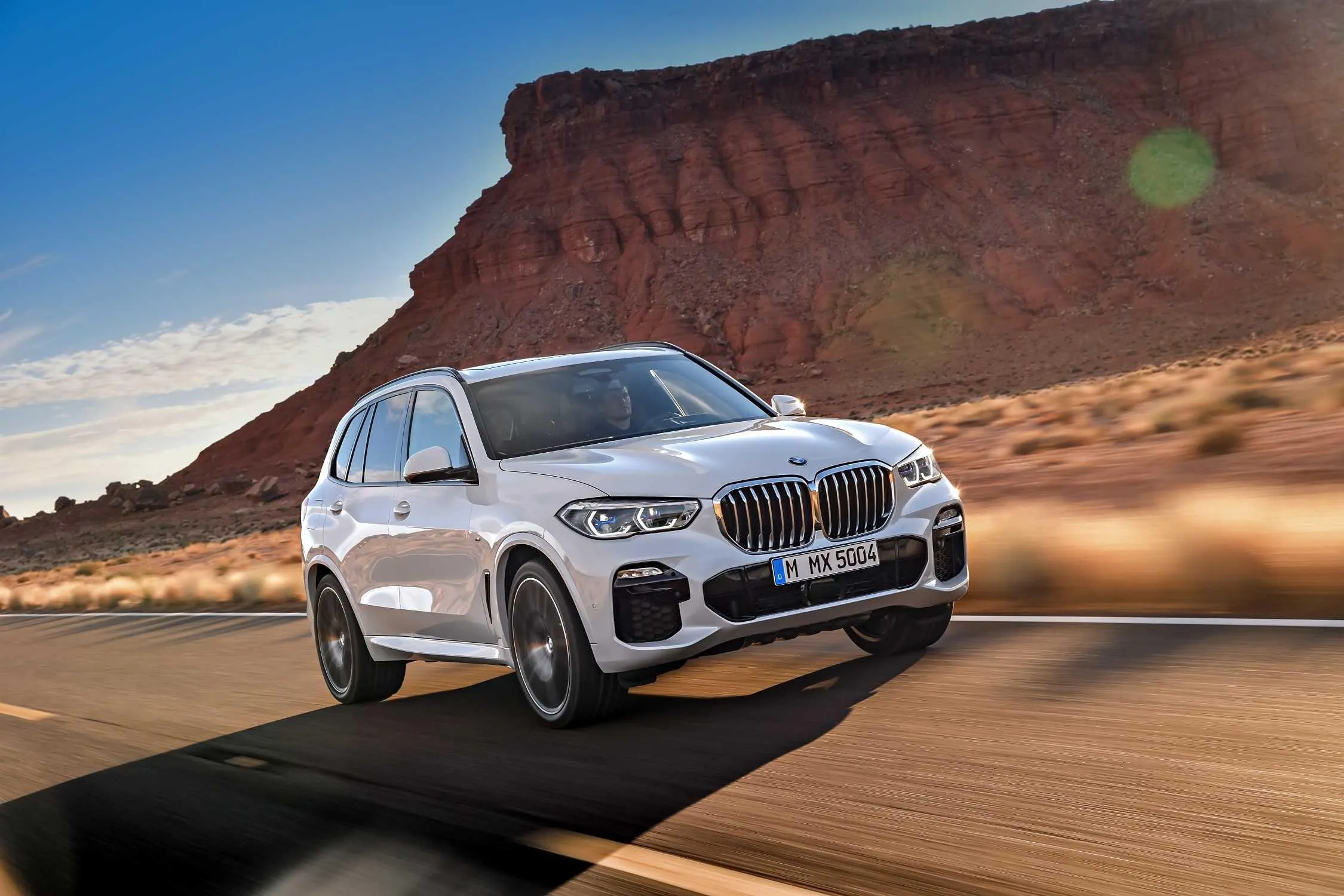 Bmw White Suv Driving on Sandy Desert Road Wallpaper