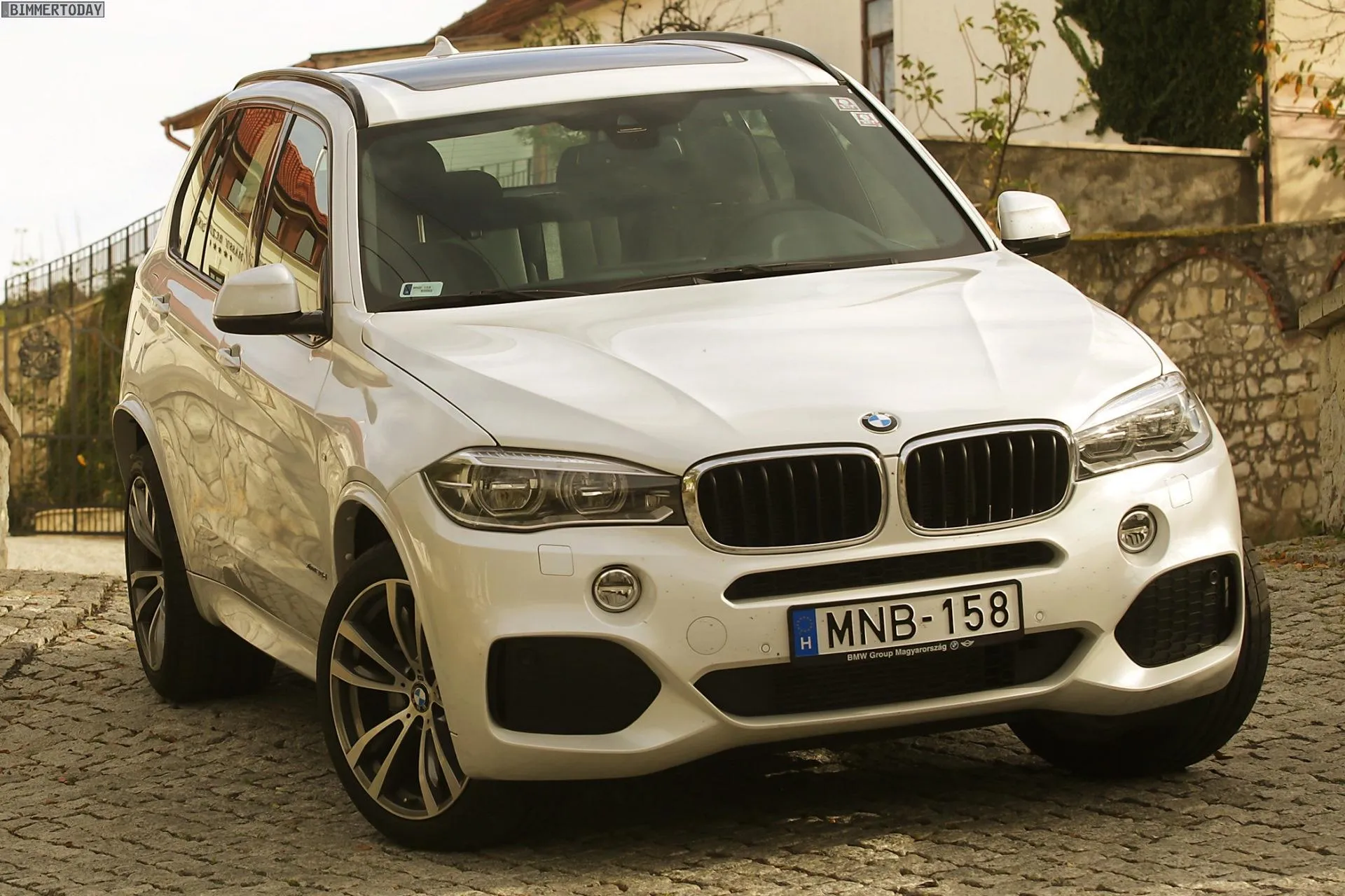 Bmw White Suv Parked on Stone Street with Old Buildings