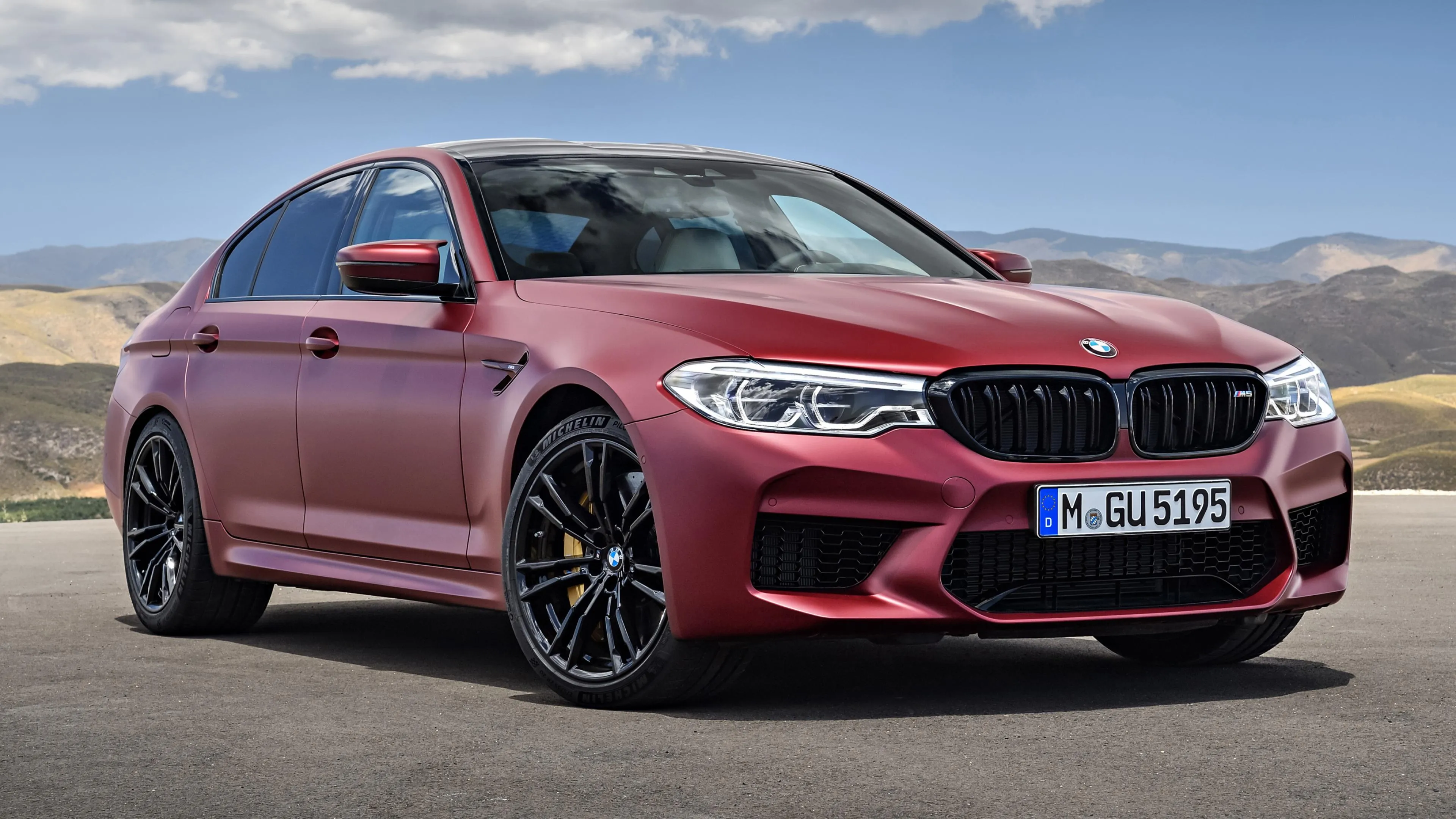 Bold Red Bmw on Pavement with Mountain Backdrop Image