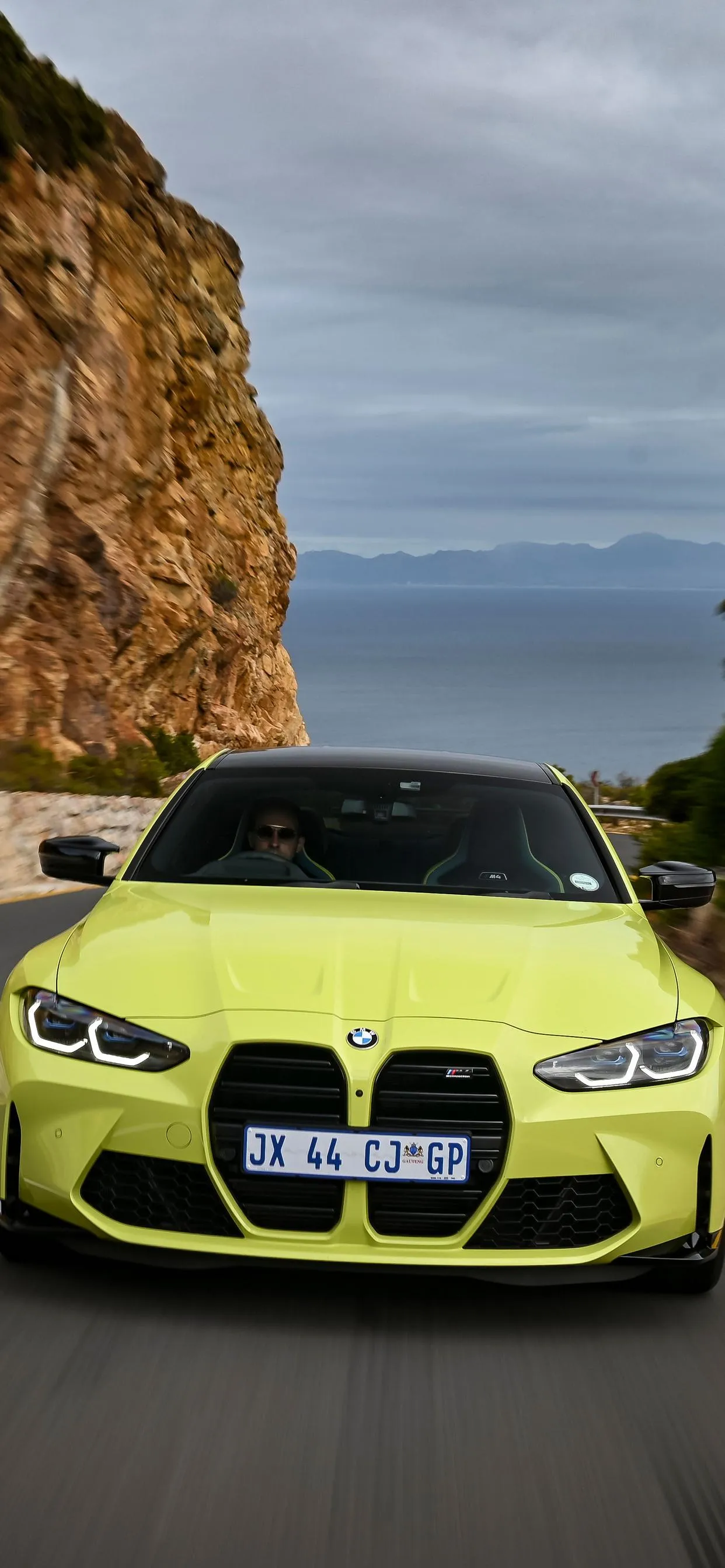 Bright Green Bmw Parked By a Cliff on a Sunny Day Wallpaper