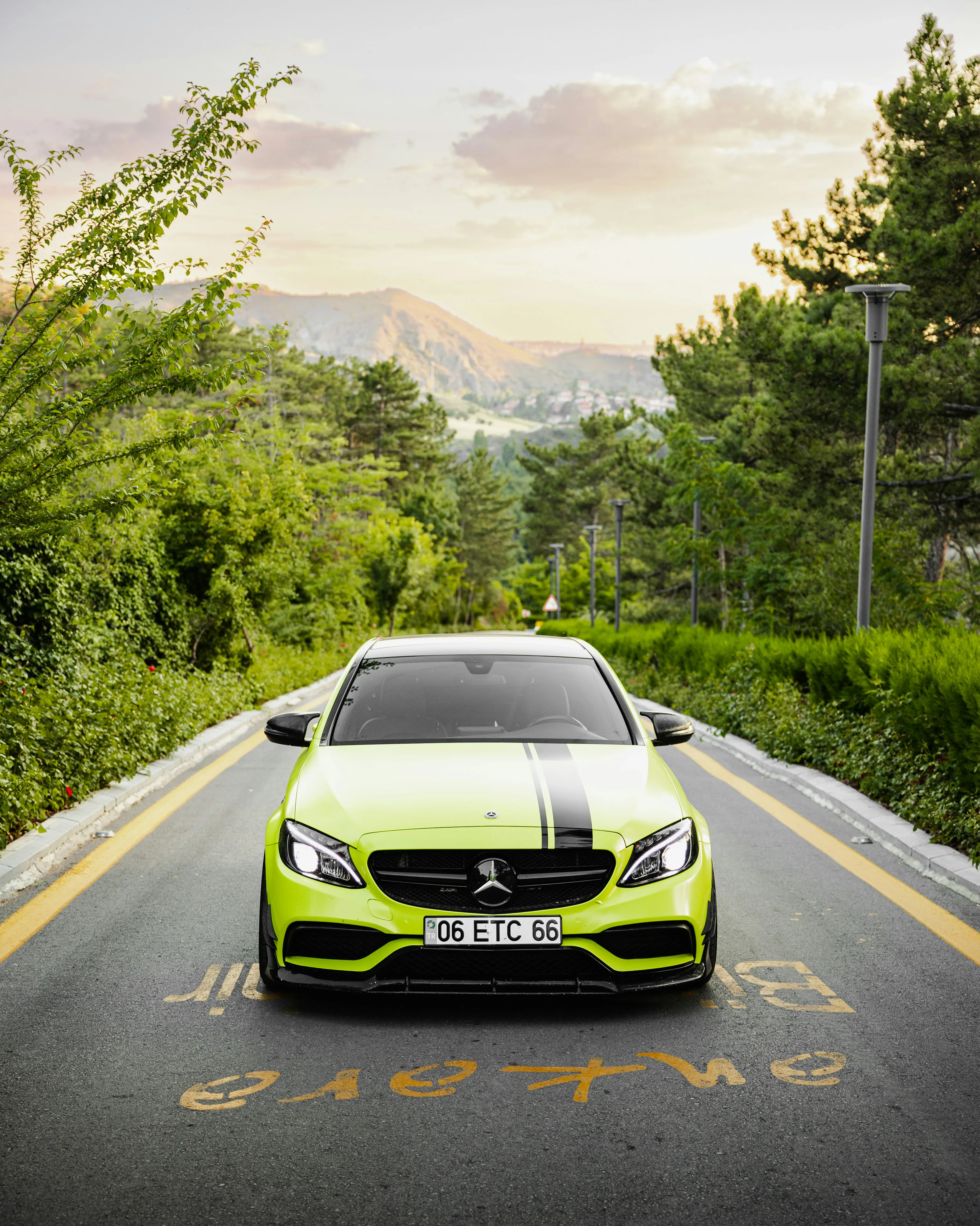 Bright Green Mercedes on Scenic Road with Hillside View