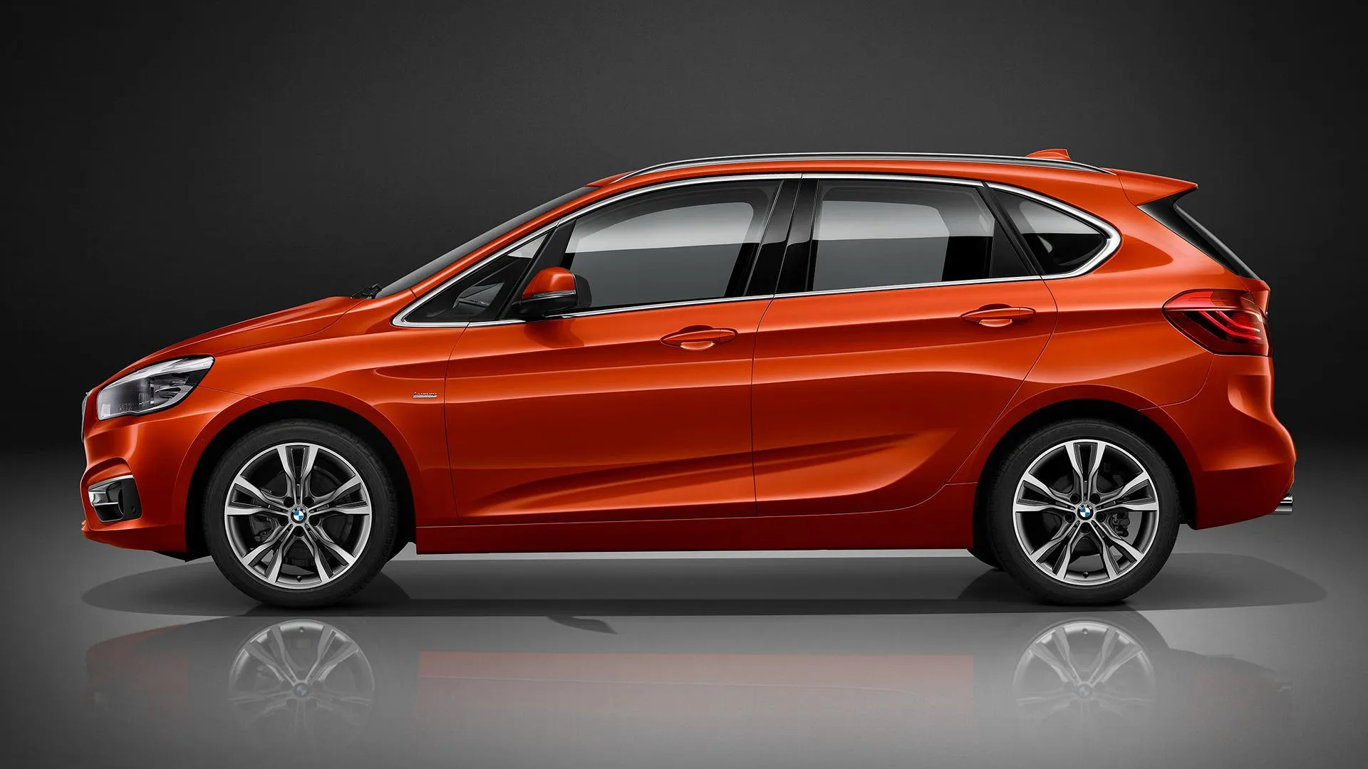 Bright Orange Bmw Compact Parked on Modern Gray Studio Floor