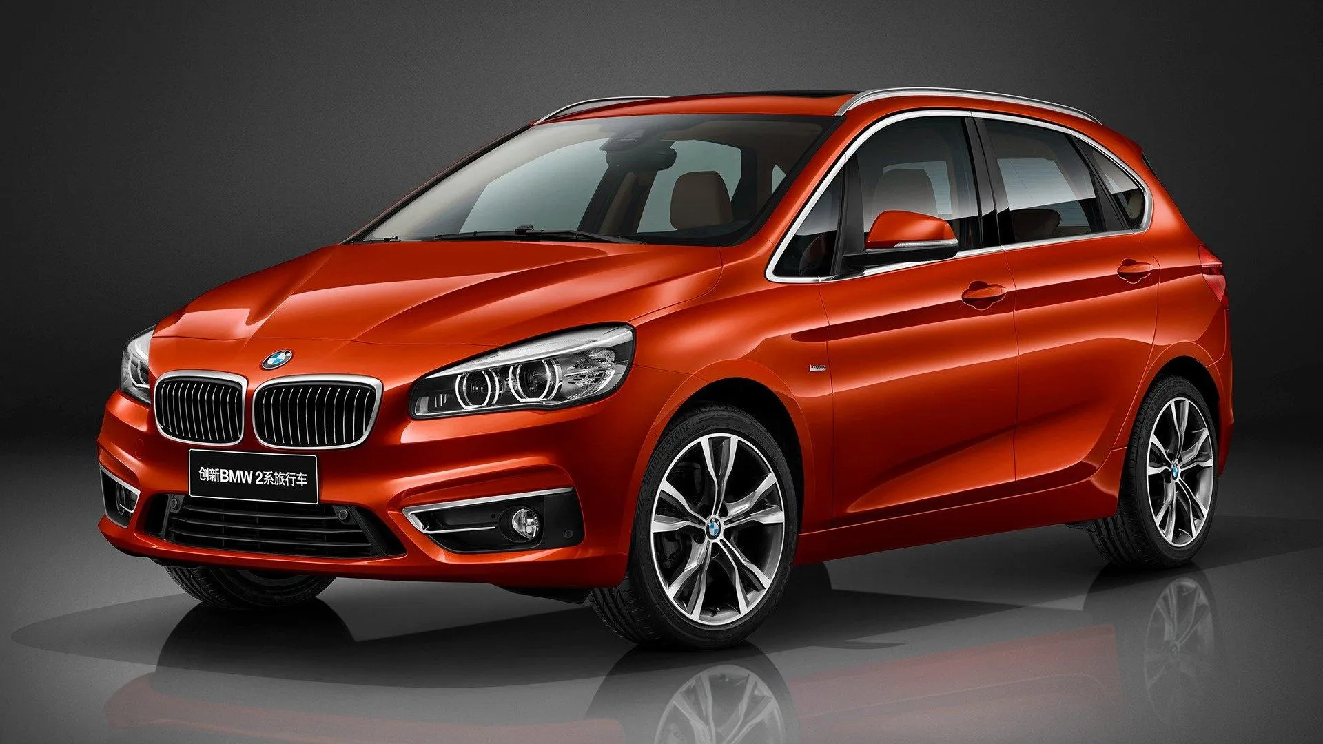 Bright Orange Bmw Crossover Displayed in Studio Setting