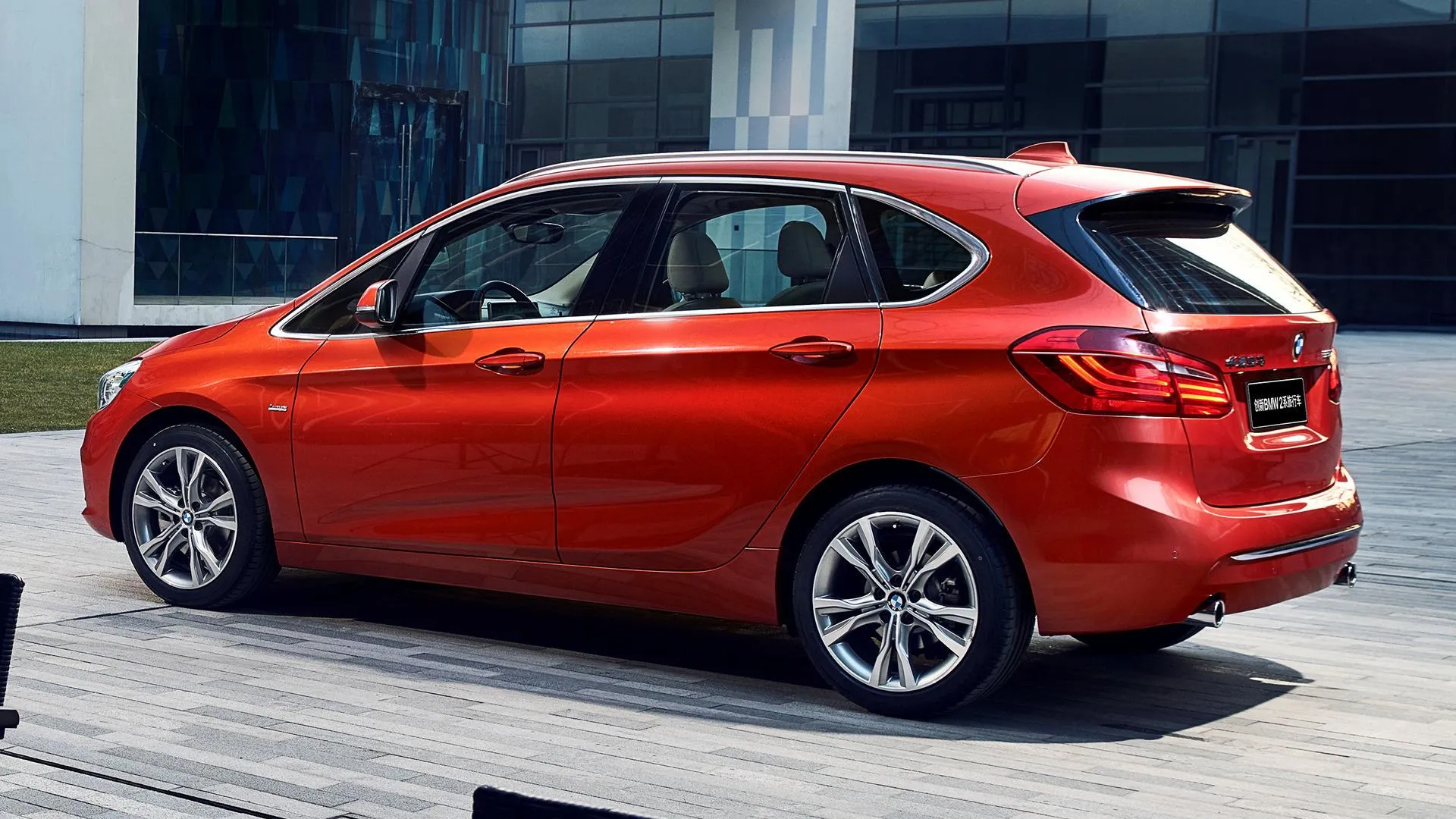 Bright Red Bmw Hatchback Parked in Front of Glass Building