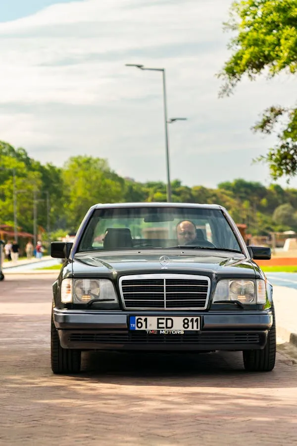 Classic Benz Facing Forward on Sunny Urban Road Wallpaper