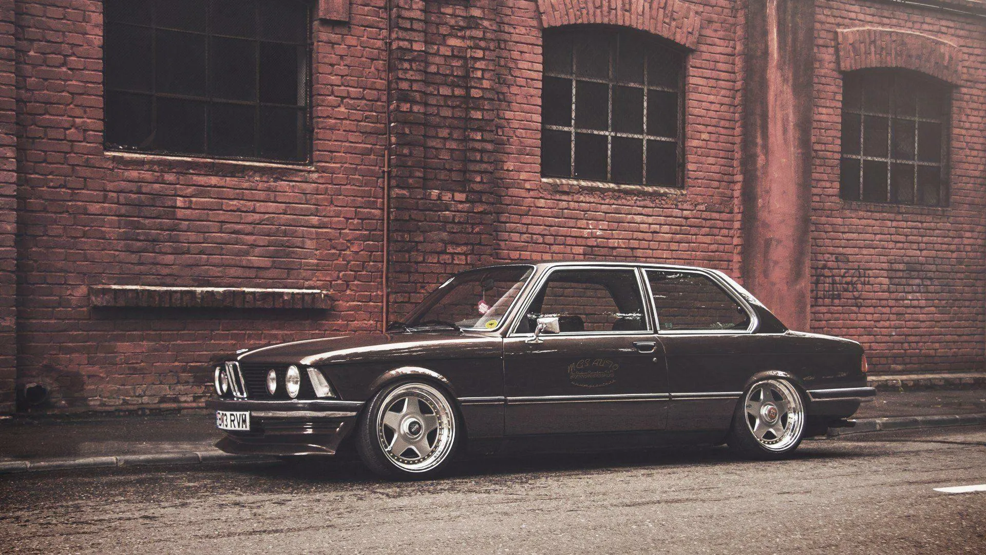 Classic Black Bmw Coupe Parked Near Brick Warehouse