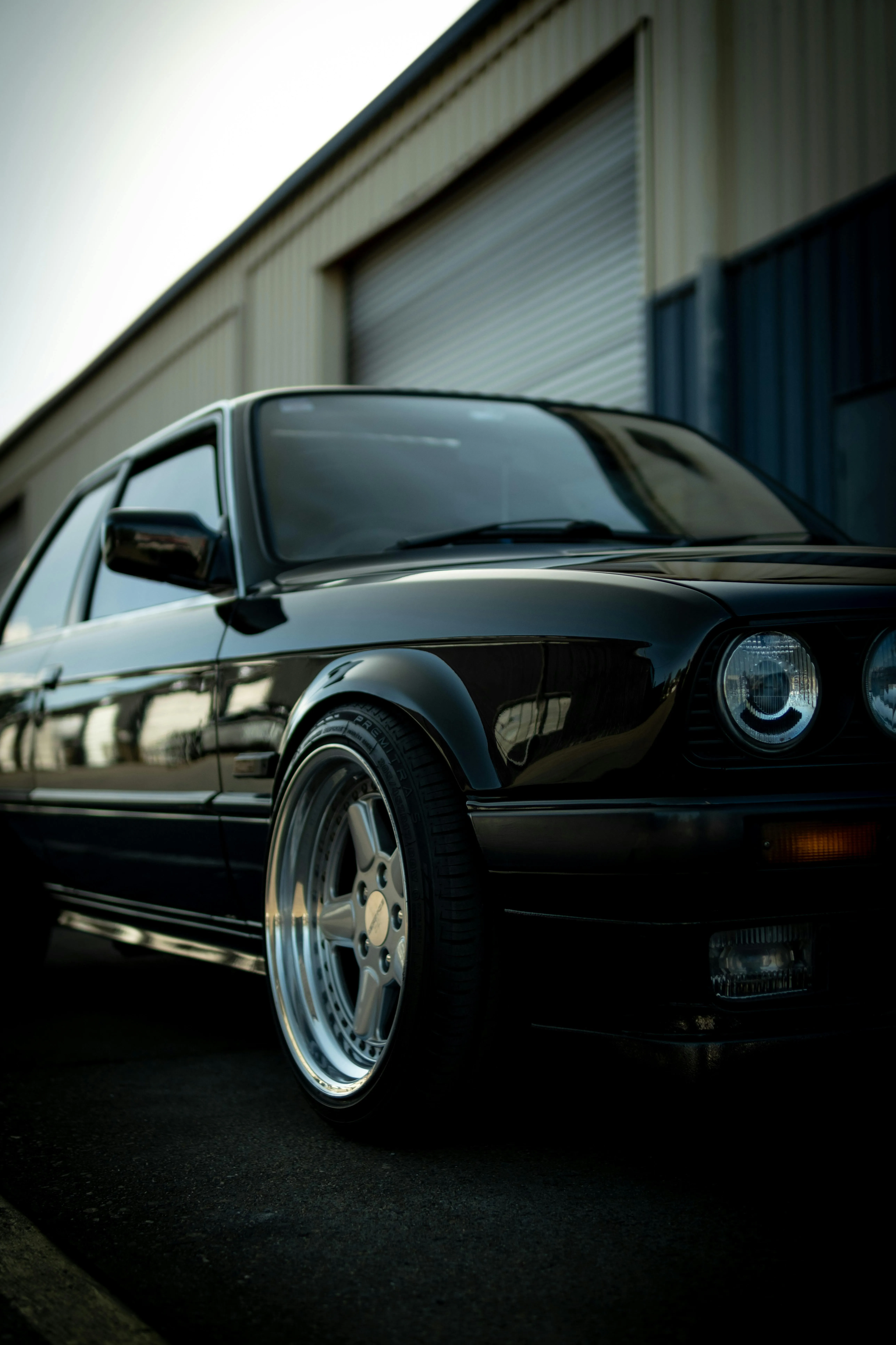 Classic Black Bmw Coupe Parked Outside Garage Image