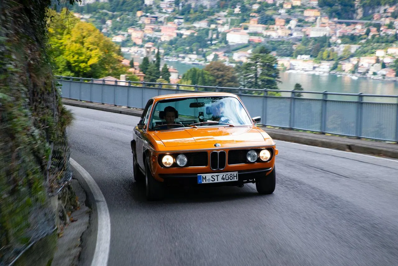Classic Bmw Car Driving Along Lake Road Scenic View