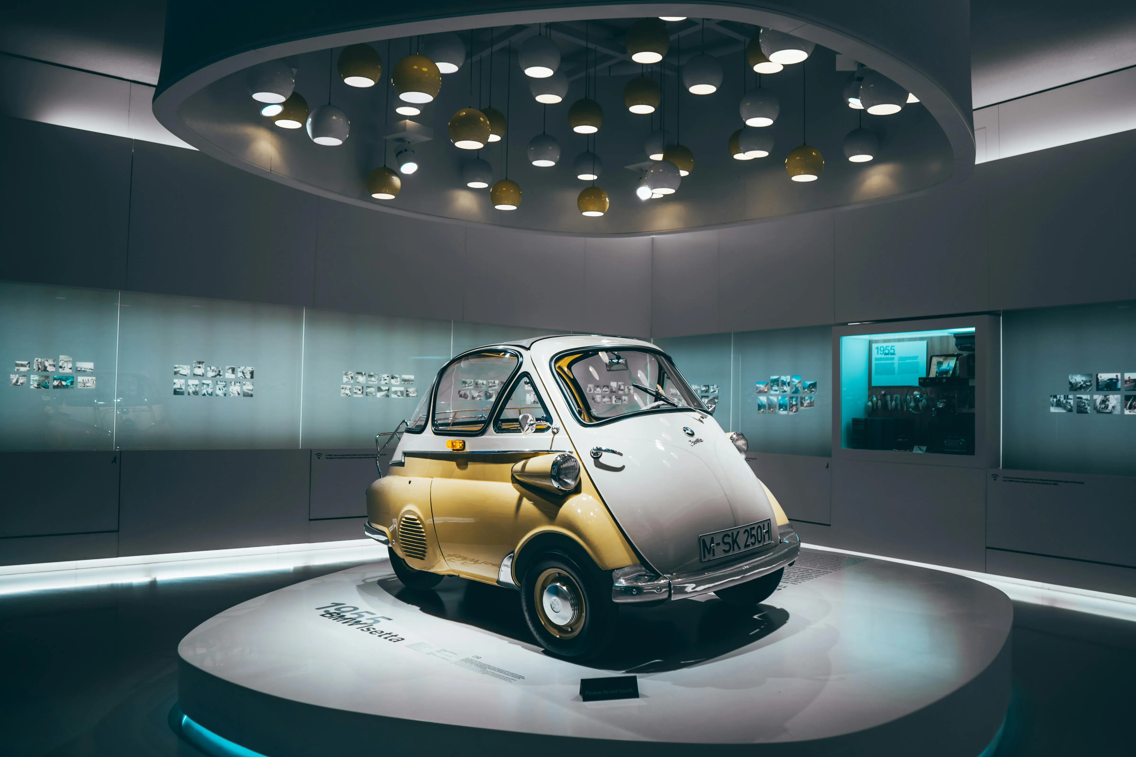 Classic Bmw Microcar Displayed Under Spotlight in Museum