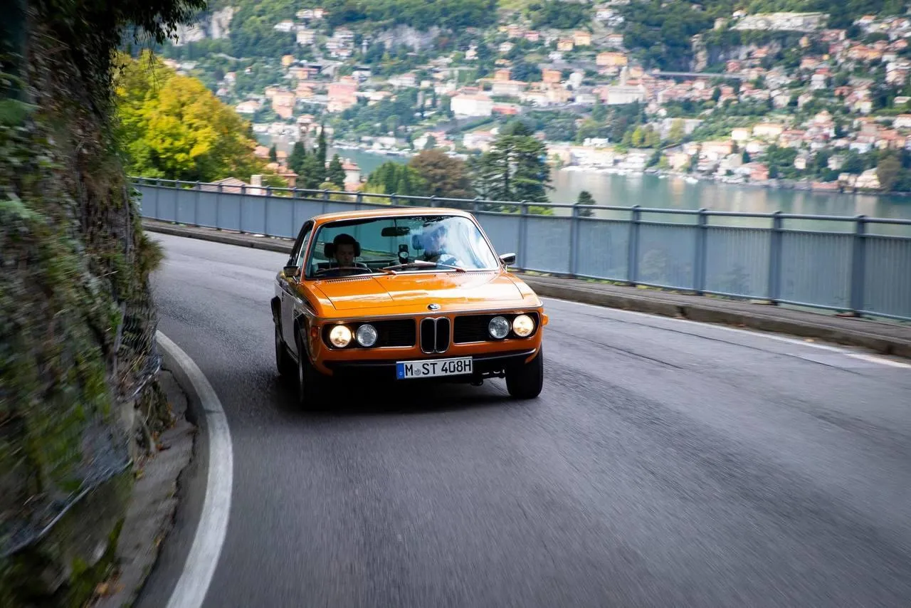 Classic Bmw Sports Car Driving Along Coastal Road Image