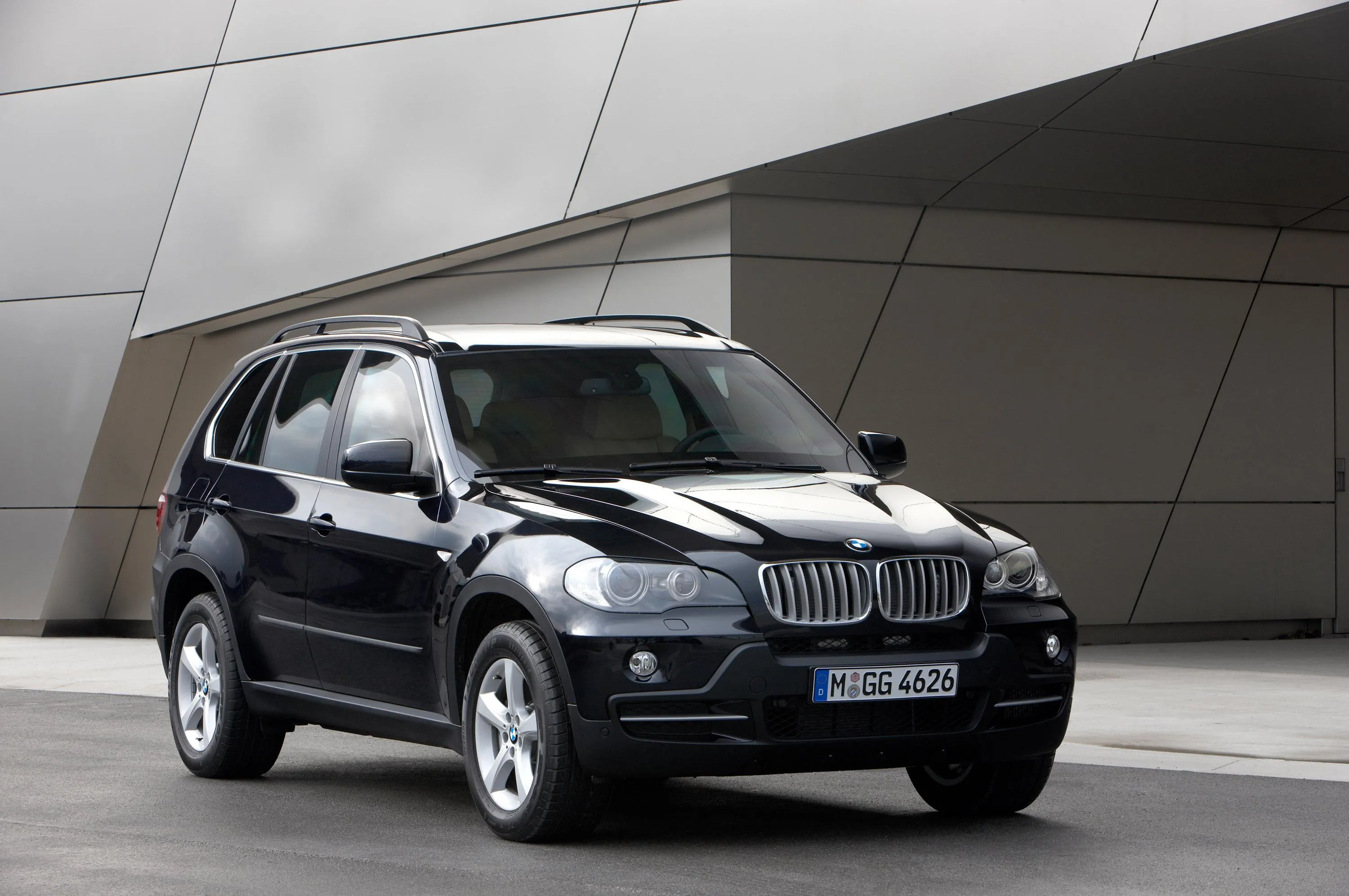 Classic Bmw Suv Parked Near Modern Architectural Wall