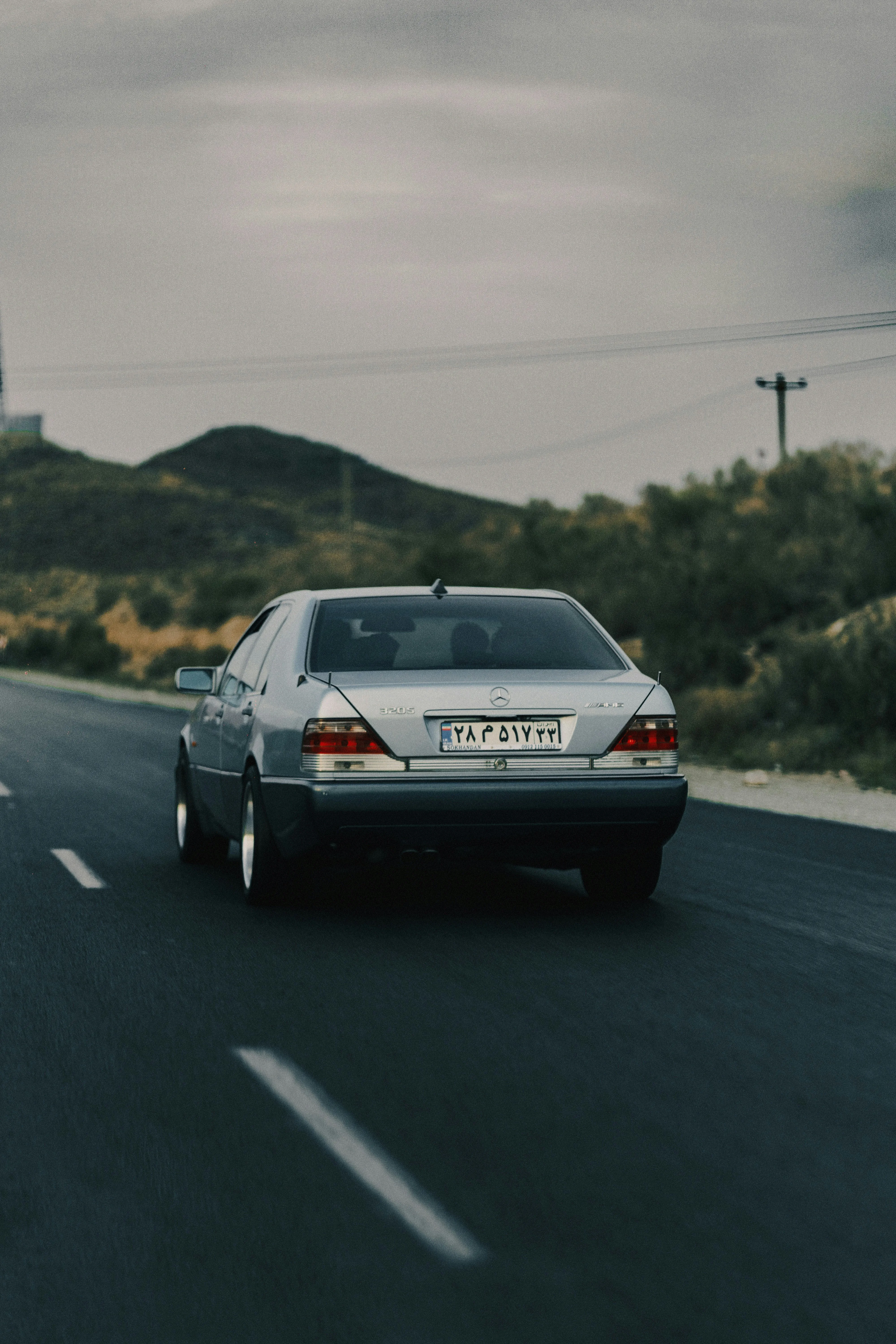 Classic Mercedes Benz Driving on Open Highway Wallpaper