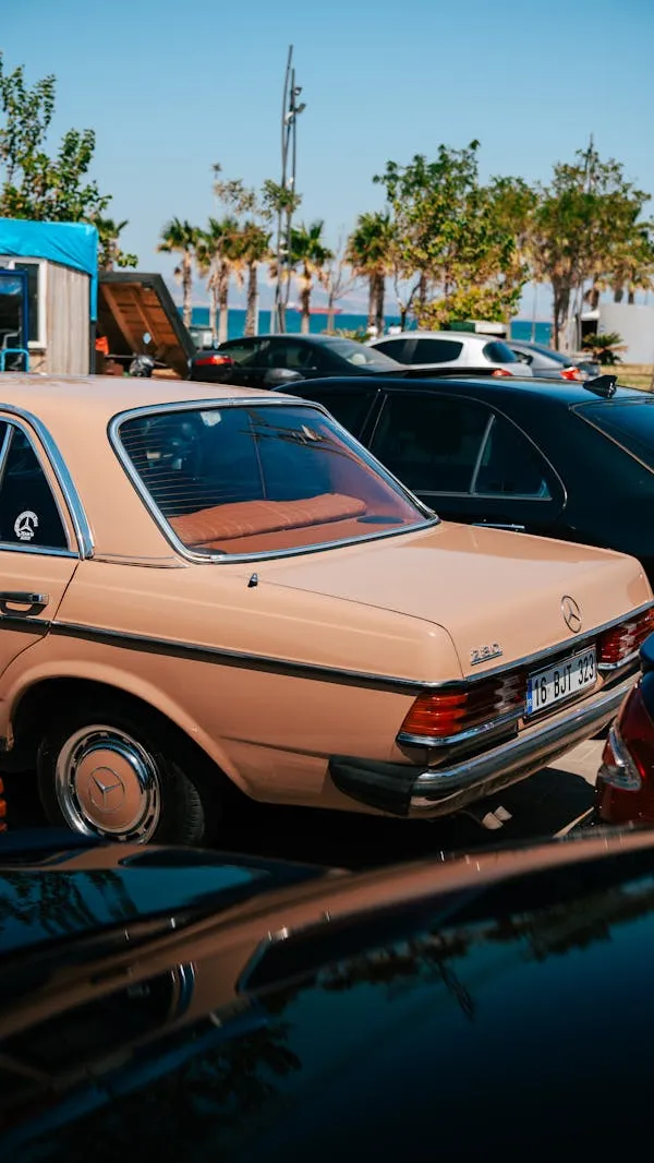 Classic Mercedes in Row of Cars at Sunny Car Lot Wallpaper